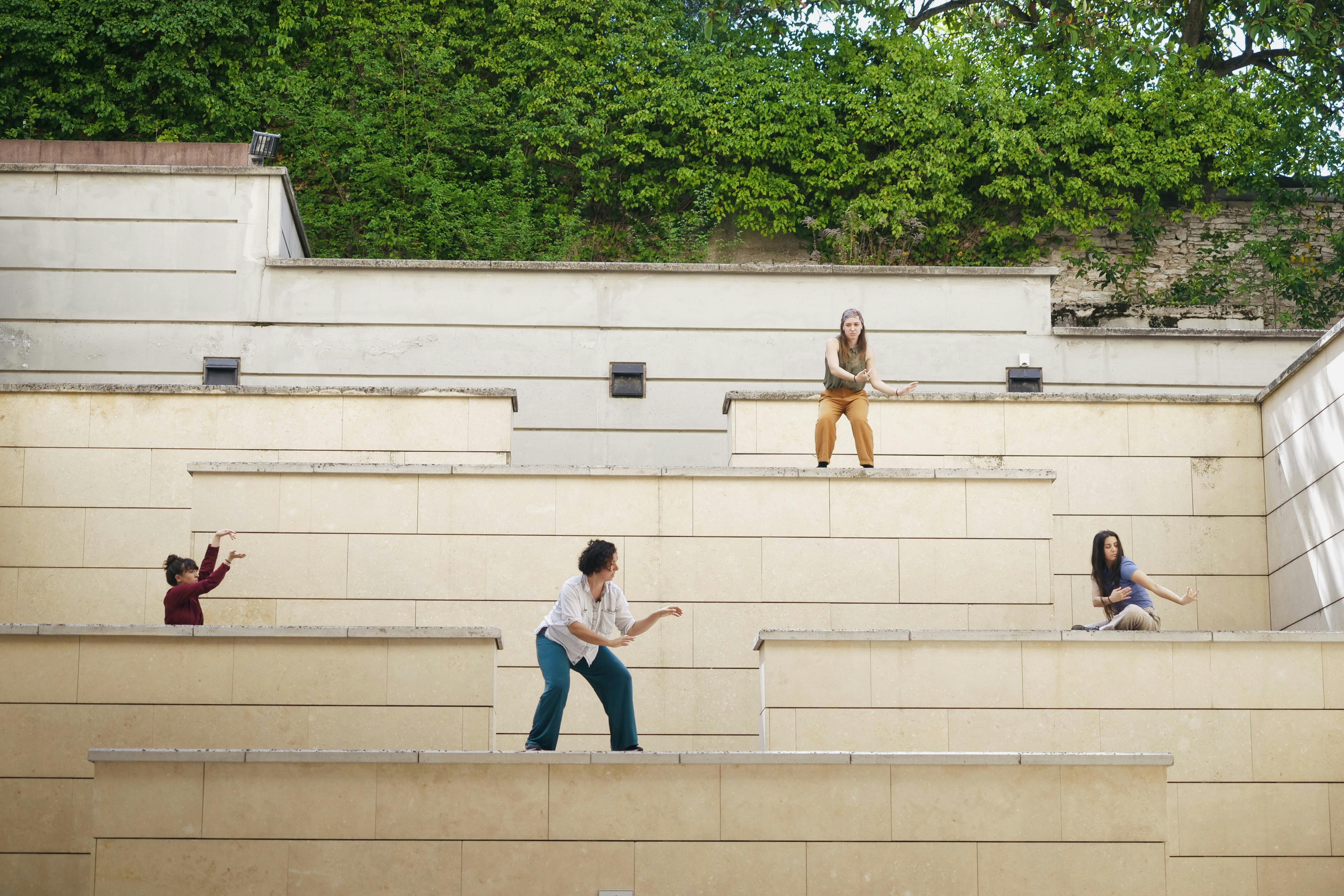 Federica e le interpreti si trovano sulla scalinata nel giardino del Mart in pose plastiche