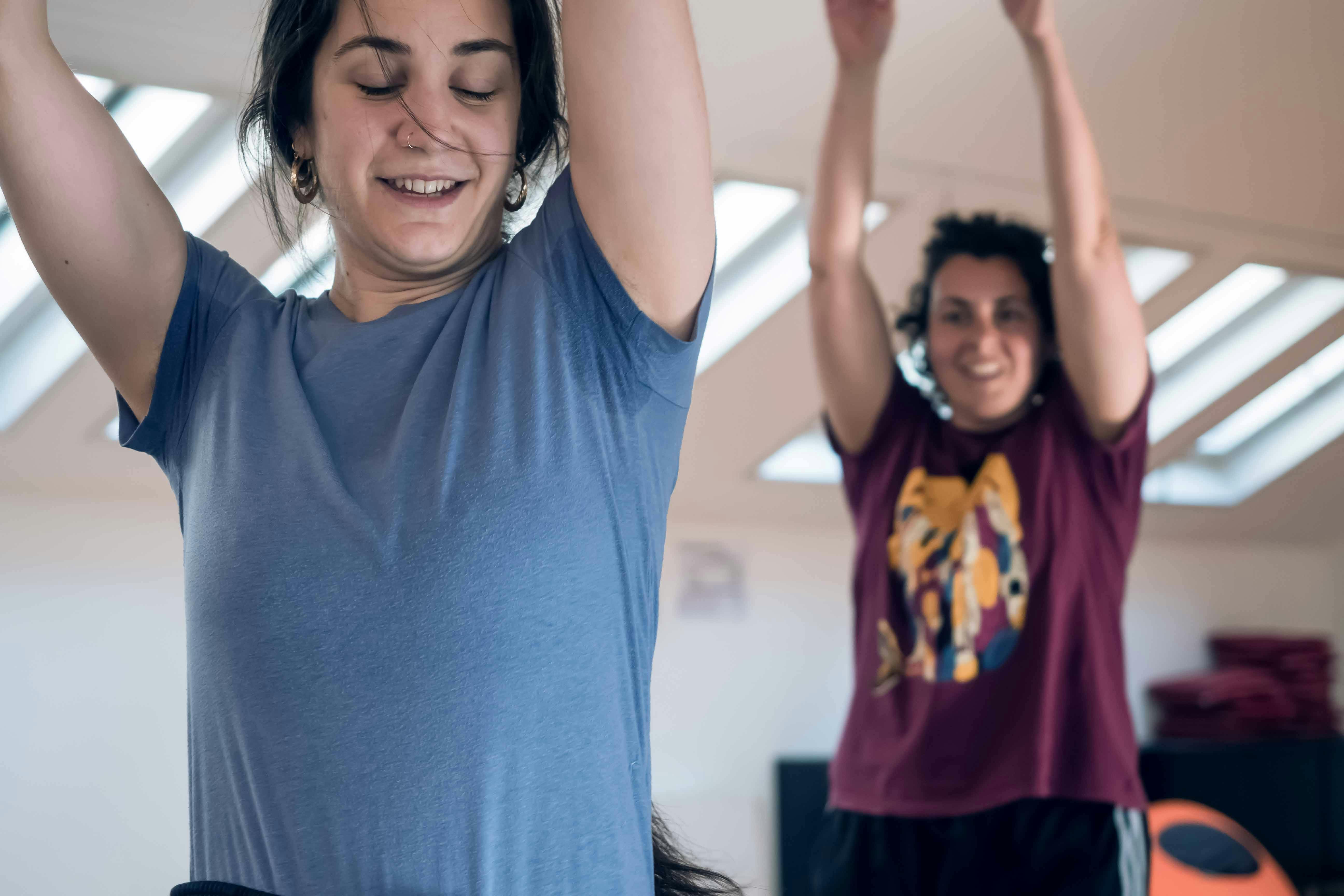 In primo piano una delle interpreti del progetto e alla sua sinistra l'autrice, entrambe con le braccia alzate al cielo