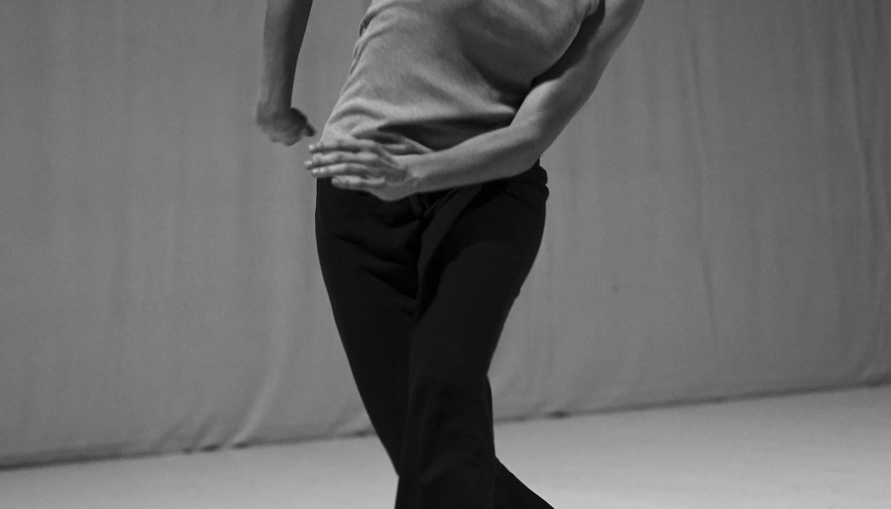 Foto in bianco e nero di danzatrice in piedi con il viso rivolto alla sua sinistra