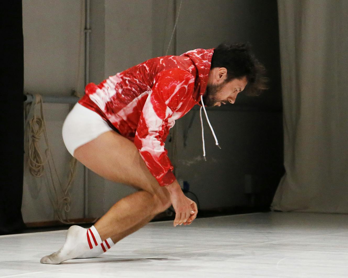Carlo Massari indossa una felpa bianca e rossa e sta in equilibrio sul dorso dei piedi 