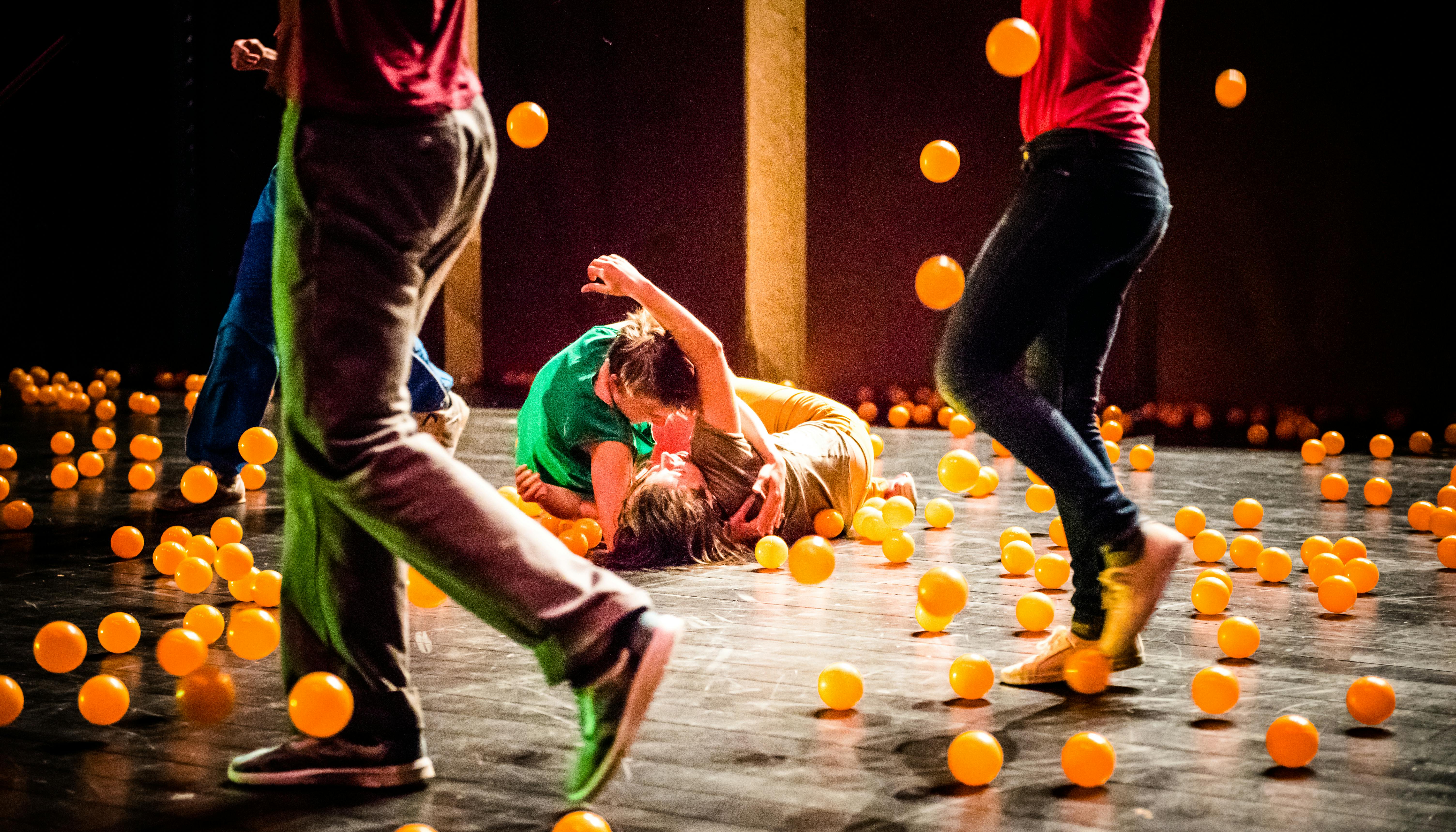 Gli artisti si esibiscono sul palco contornati da palline arancioni