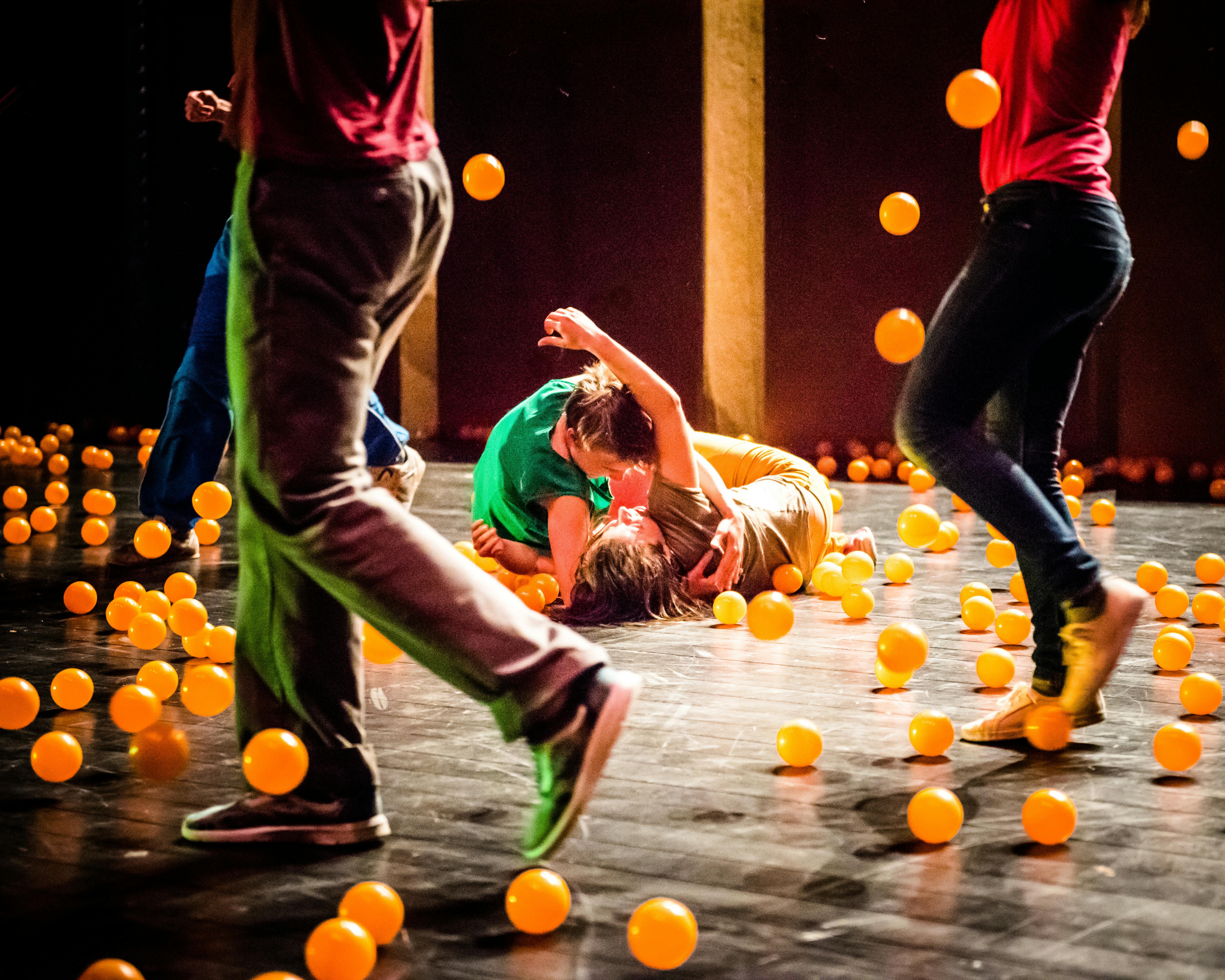 Gli artisti si esibiscono sul palco contornati da palline arancioni
