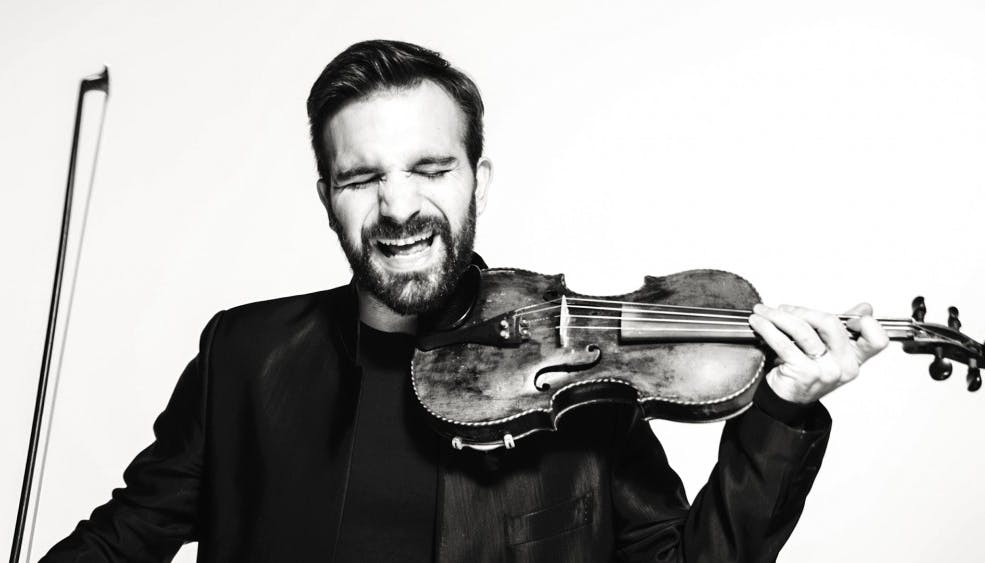 Mauro Durante in a black and white photo sings and plays the violin 