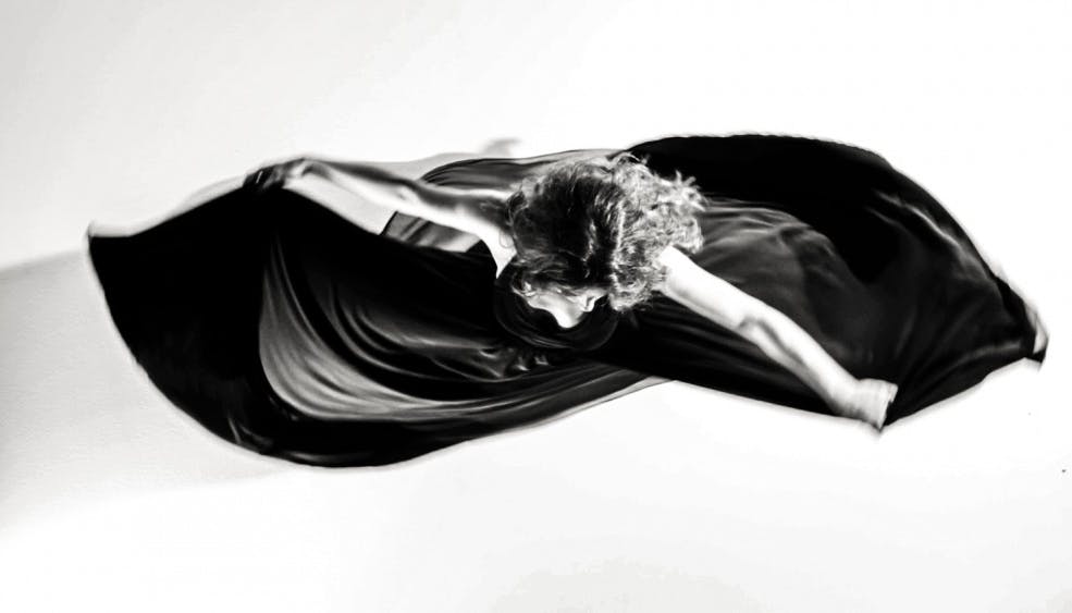Silvia Perrone in una foto dall'alto in bianco e nero gira tenendo il vestito con le braccia alzate