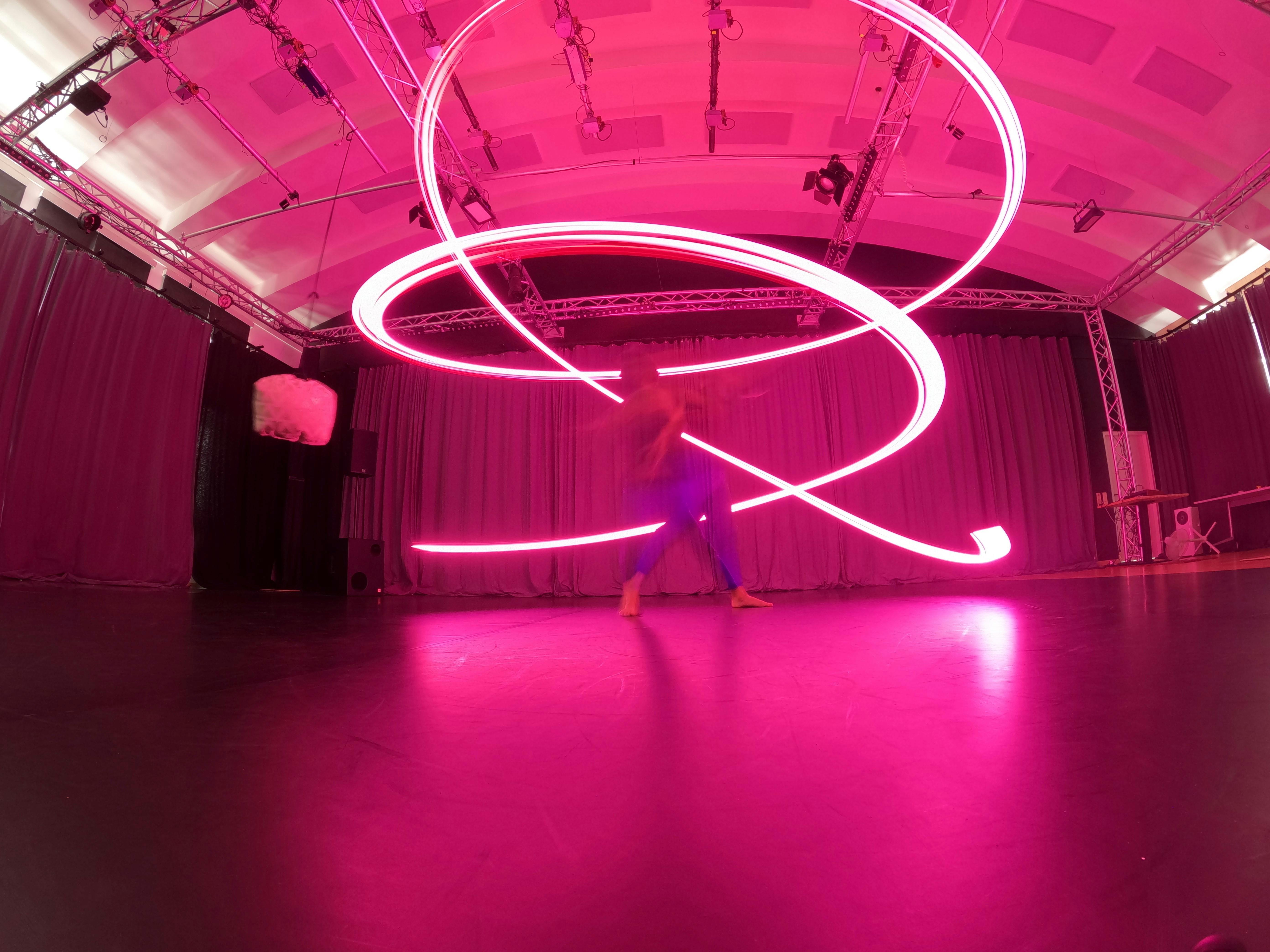 Lorenzo Morandini in movimento con un led di luce rosa alle spalle