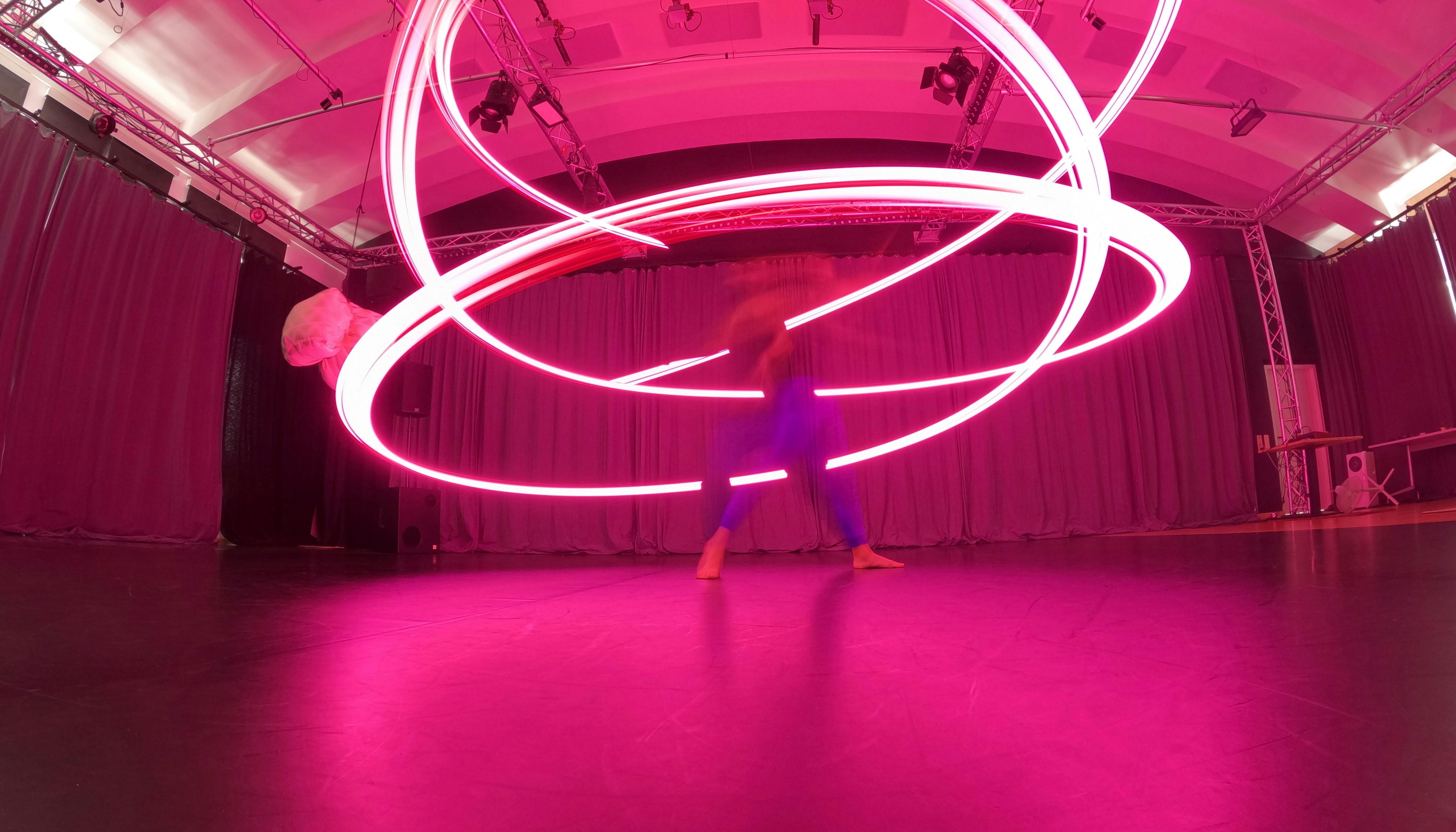 Lorenzo Morandini in motion with a pink LED lighting up the room