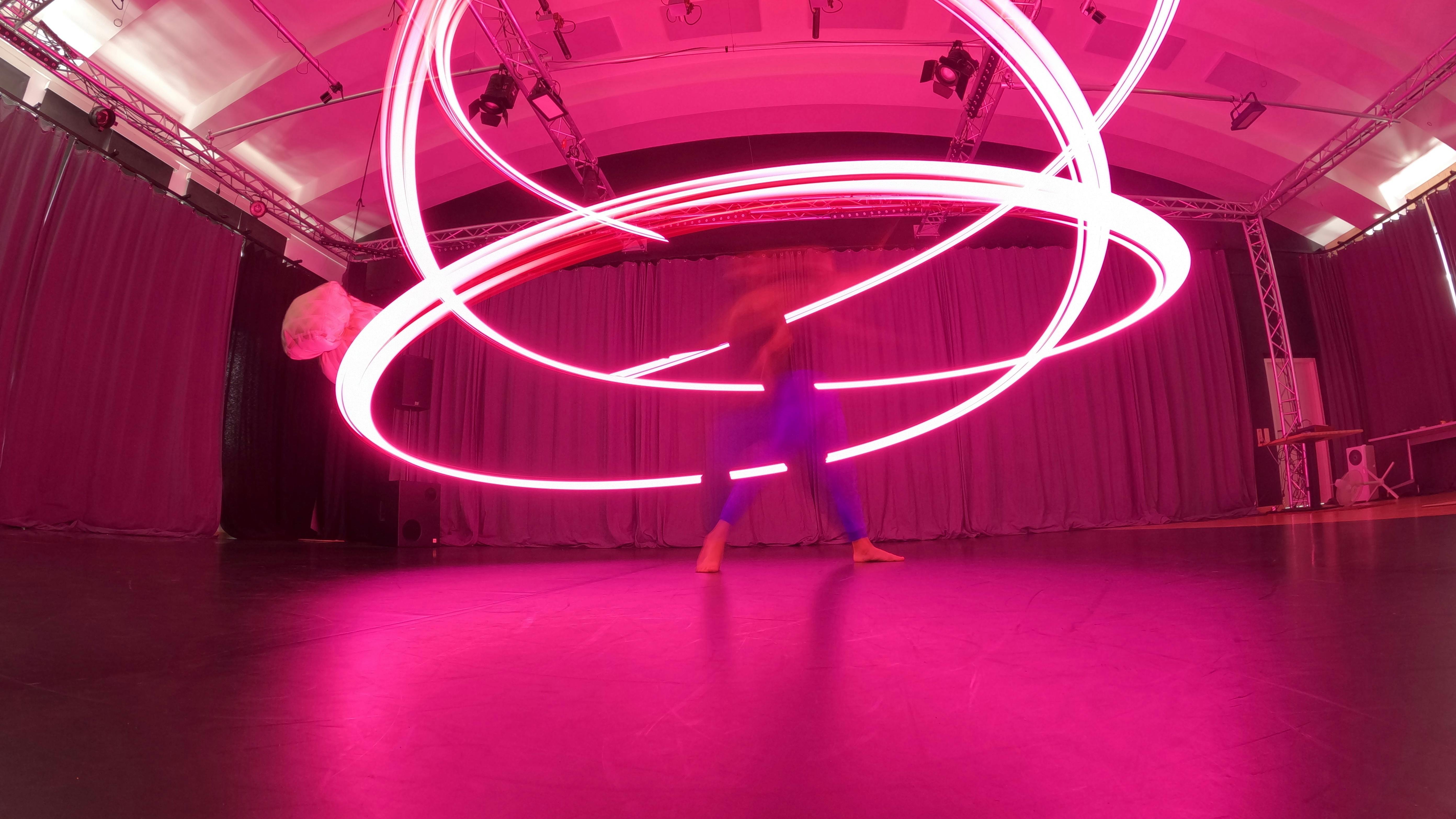 Lorenzo Morandini in motion with a pink LED lighting up the room