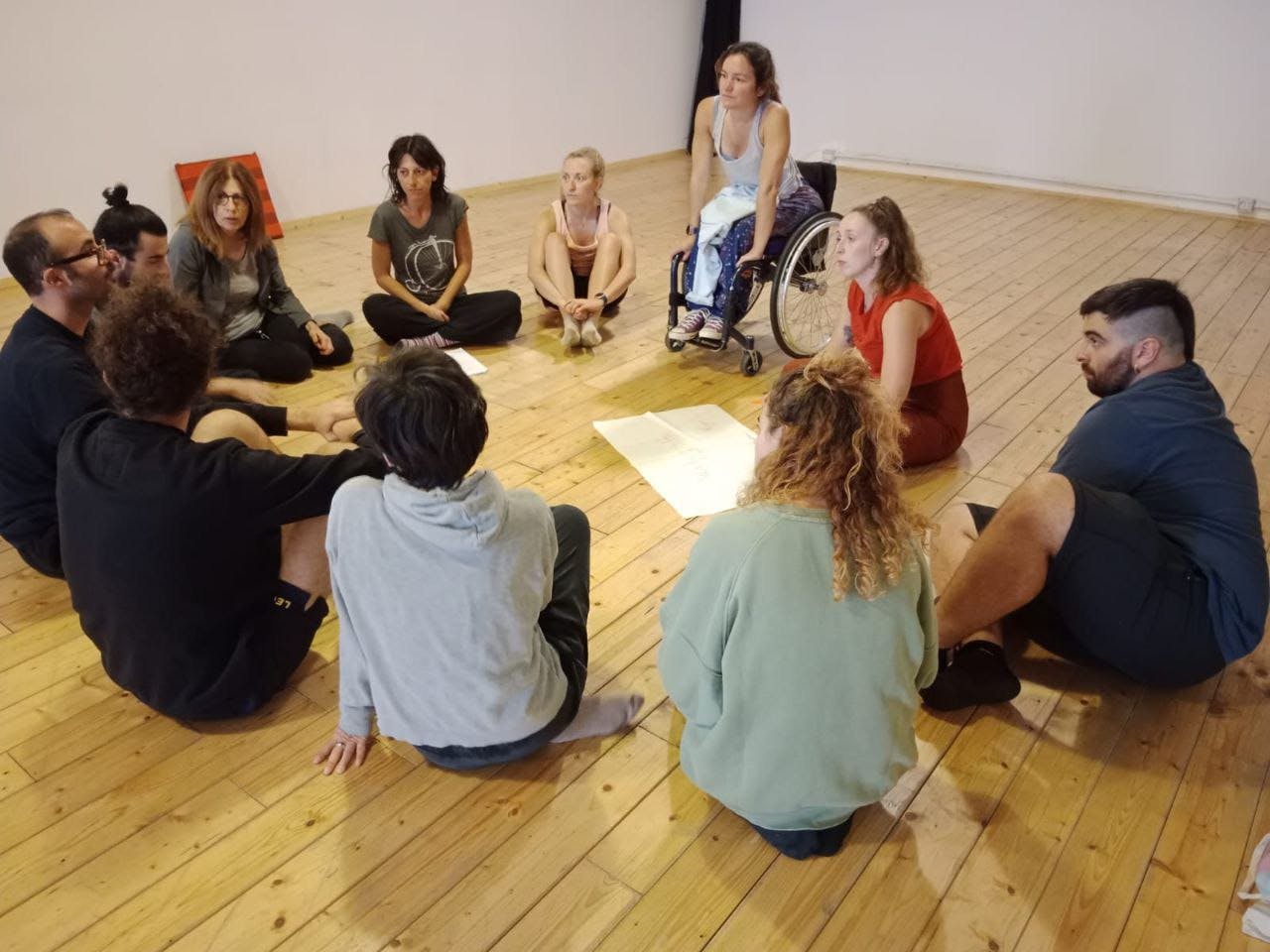 Artists and trainers confront each other in a circle