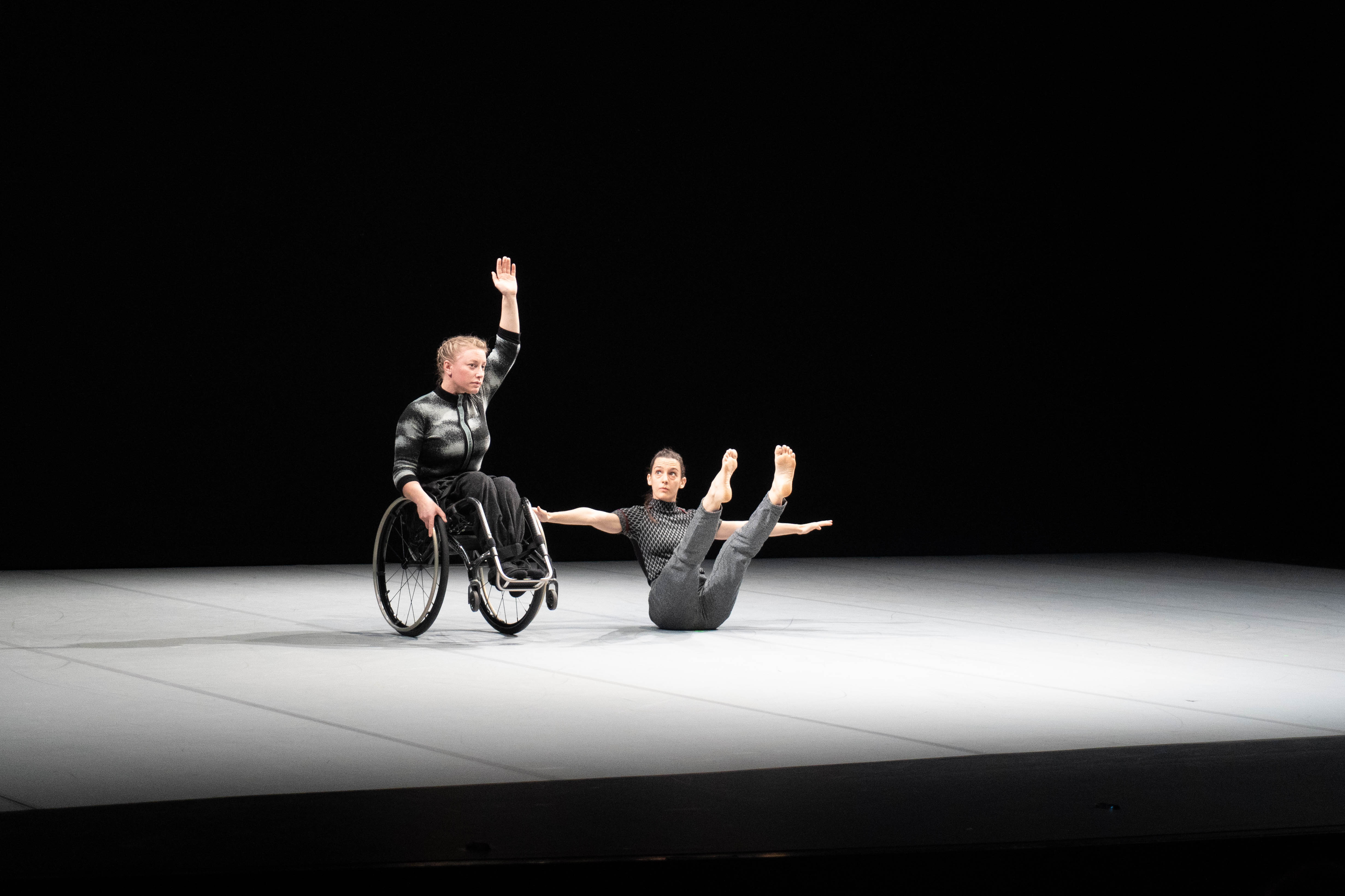 Due danzatrici, la prima da sinistra in equilibrio sulle ruote della carrozzina la seconda al suo fianco in equilibrio sul bacino