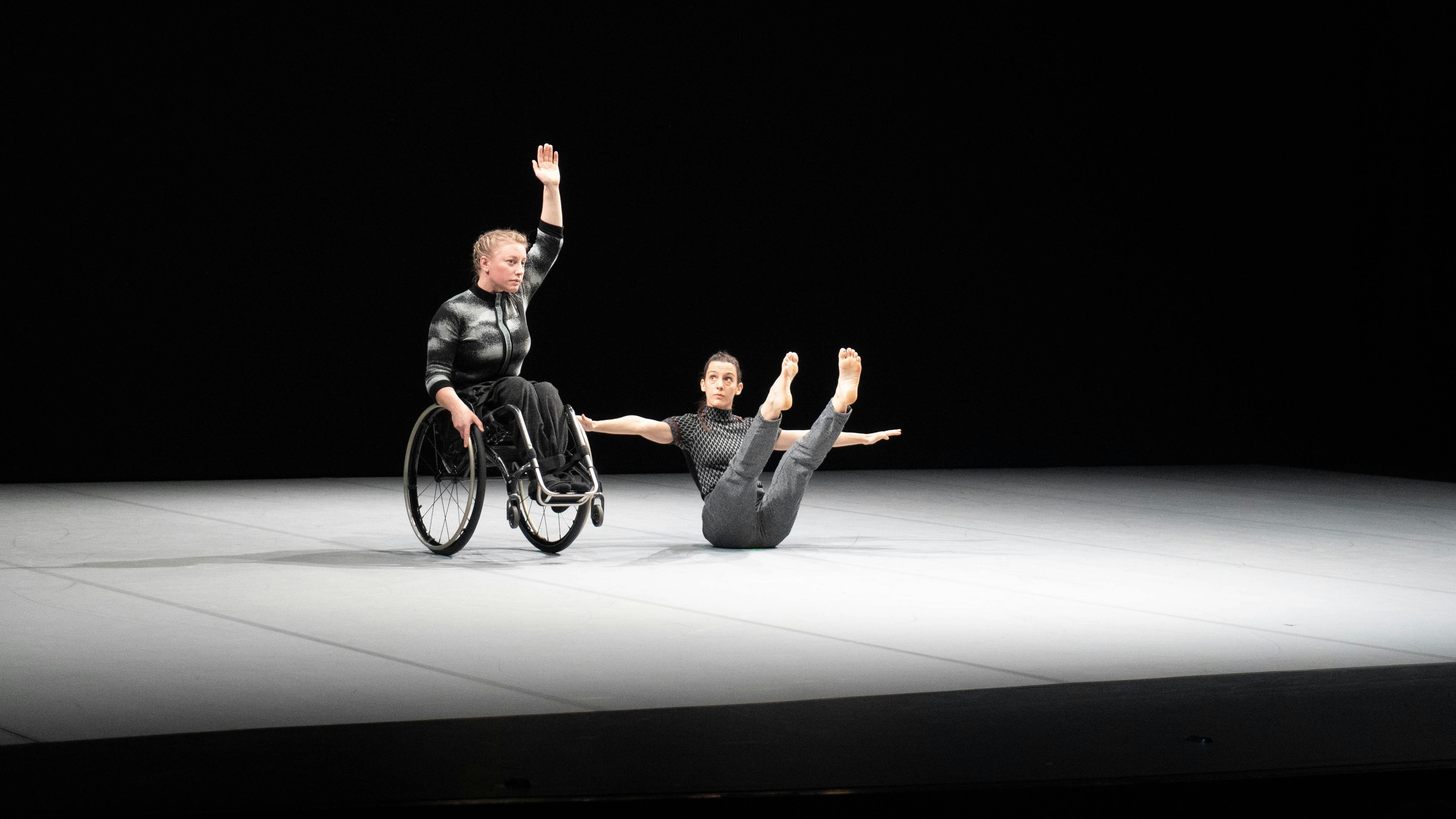 Due danzatrici, la prima da sinistra in equilibrio sulle ruote della carrozzina la seconda al suo fianco in equilibrio sul bacino