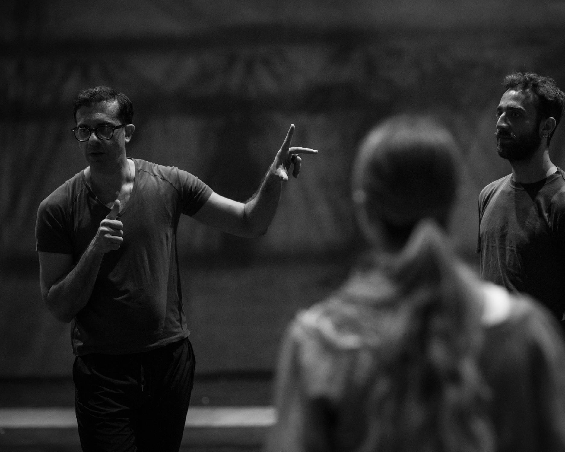 A black and white photo of Alessio Maria Romano talking to a girl and a boy