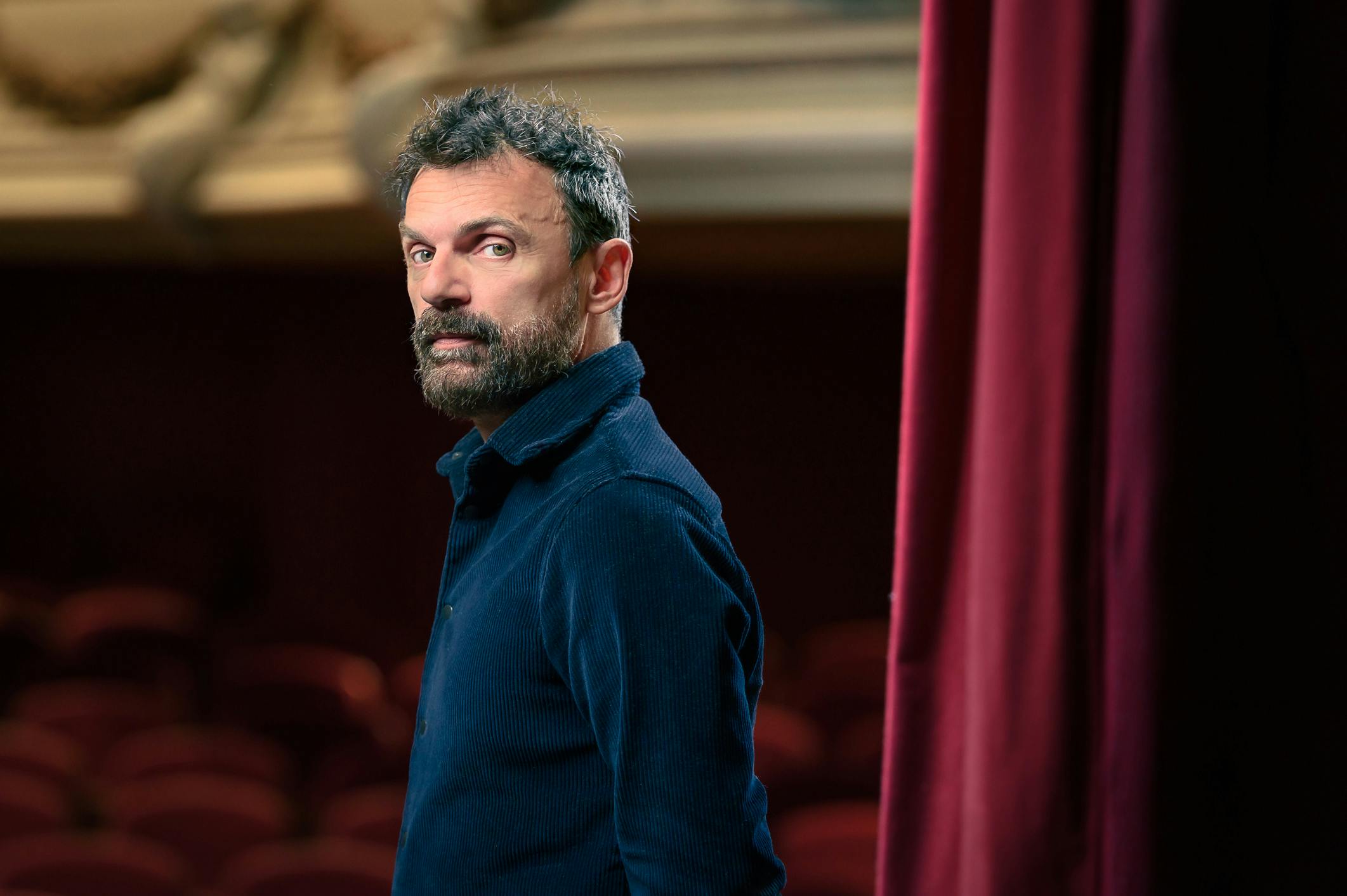 Portrait of Emilio Calcagno in a theater wearing a blue shirt