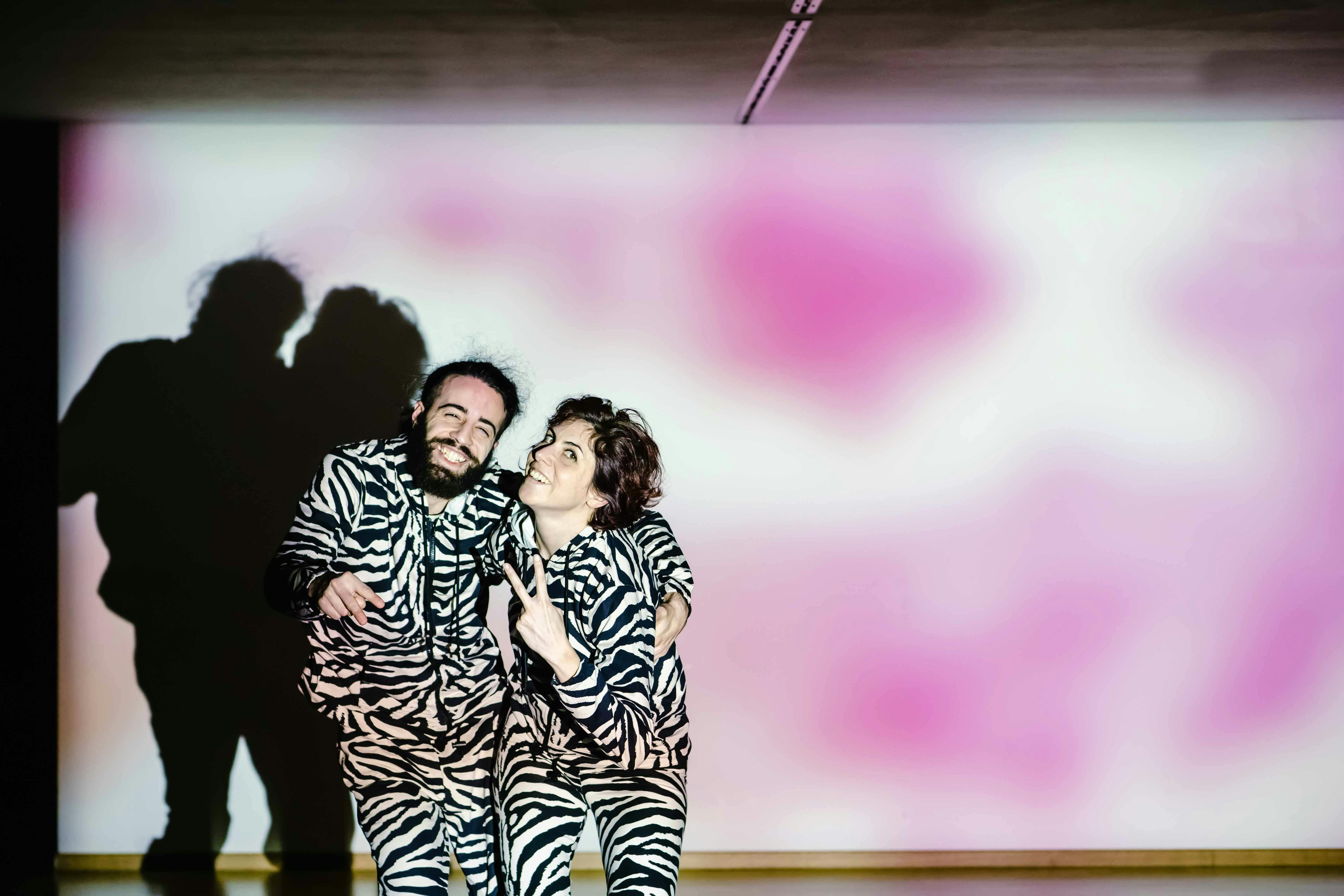 Giselda and Michael dressed in black and white patterned pants and sweatshirt as the zebra are posing embraced