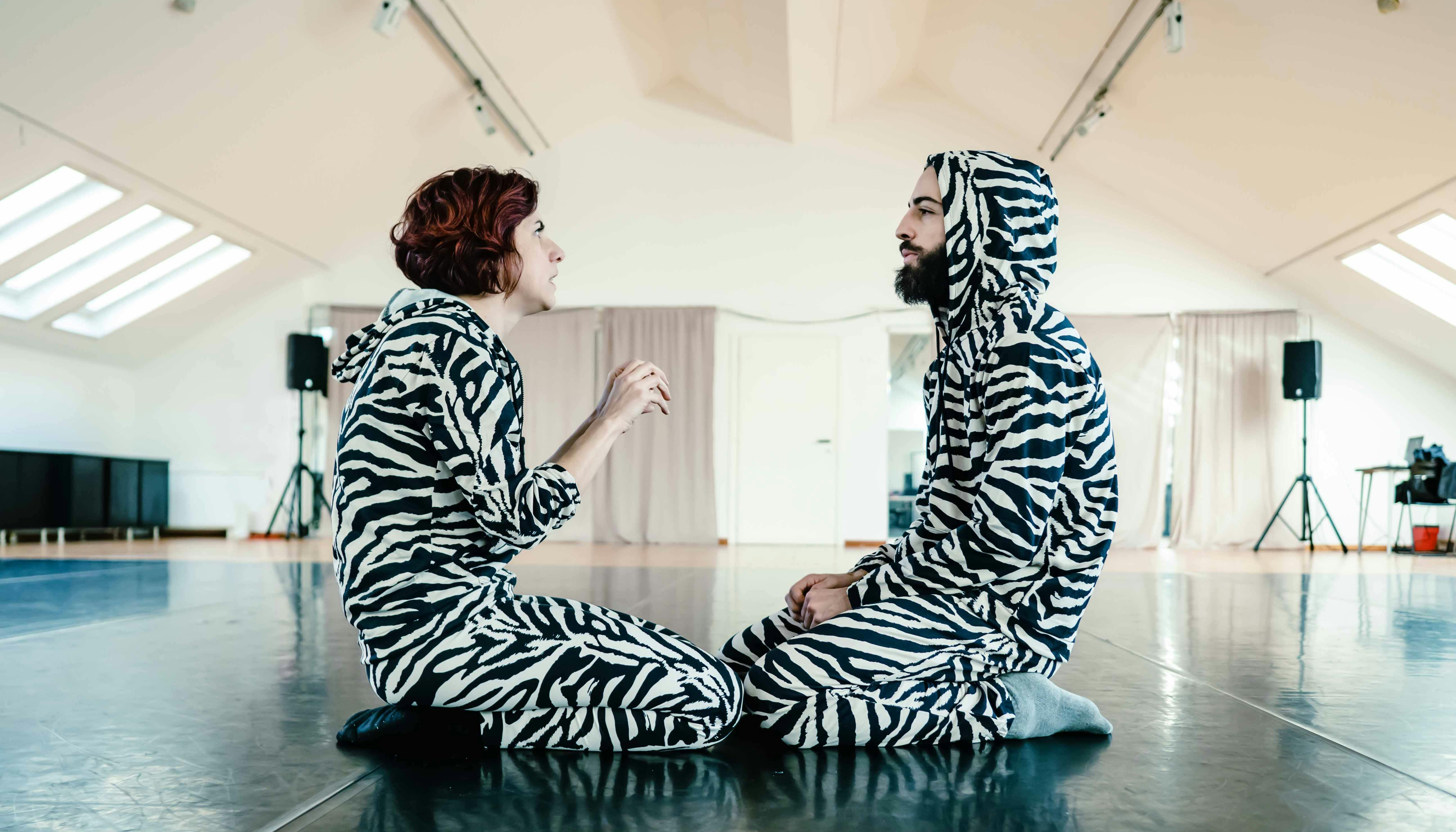 Giselda and Michael dressed in zebra pants and sweatshirt kneeling in front of each other
