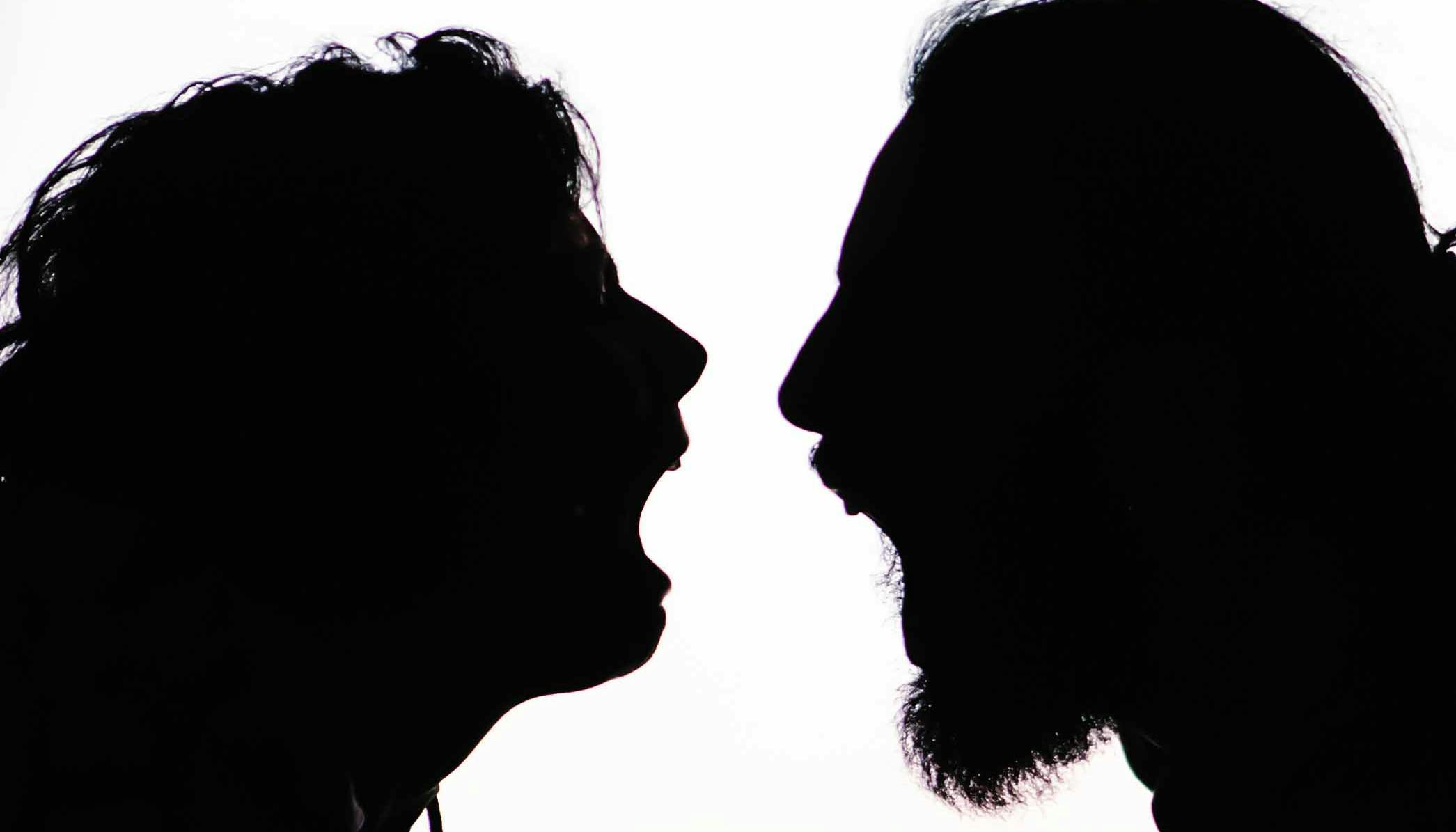 Backlit photo of Giselda and Michael in profile facing each other with mouths open as if in a scream