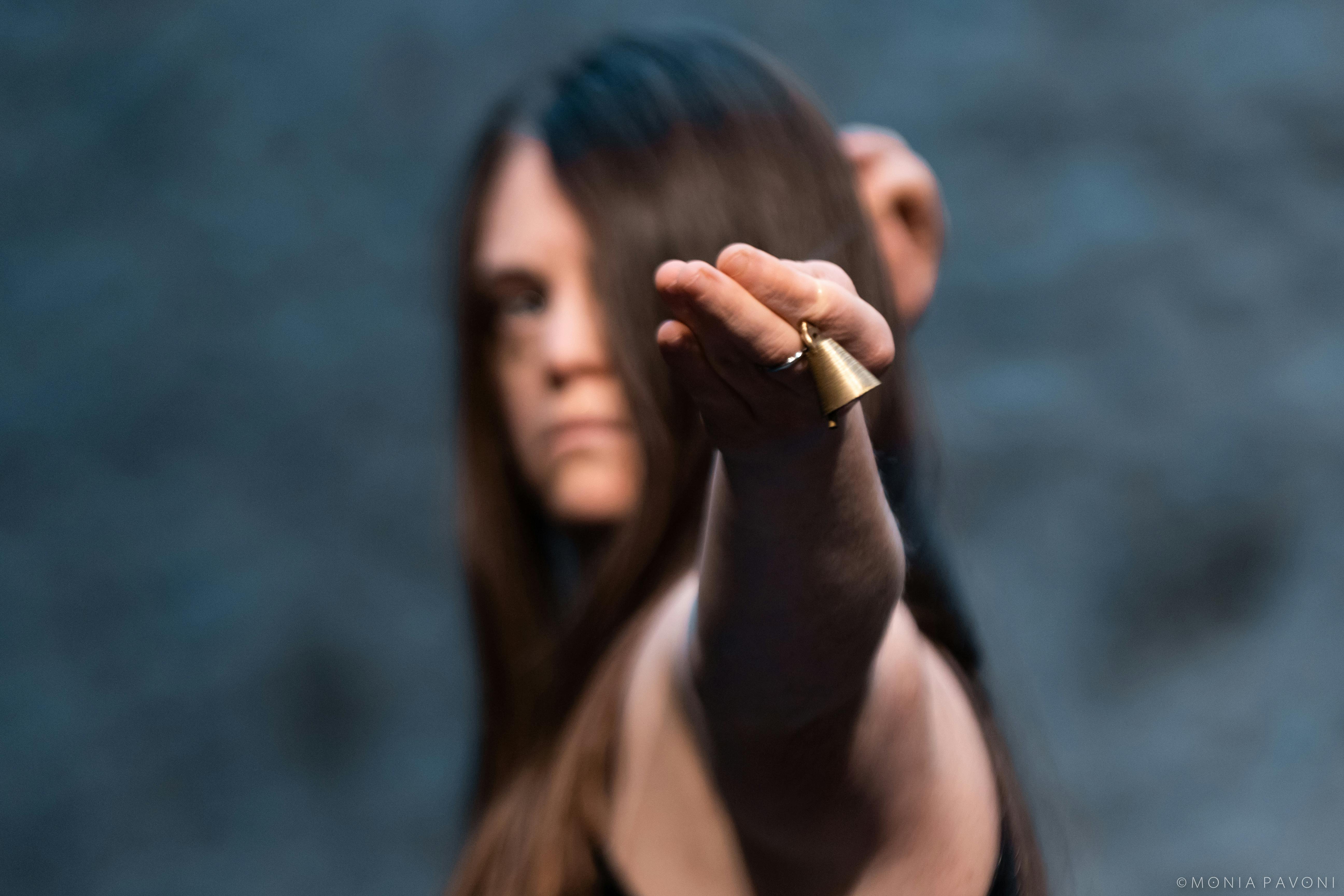 Close-up of a performer's hand showing a golden bell