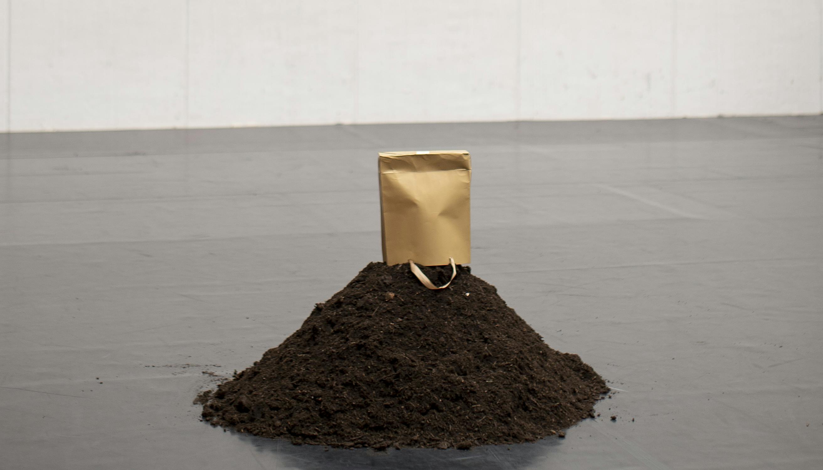 A pile of soil covered by a paper bag.