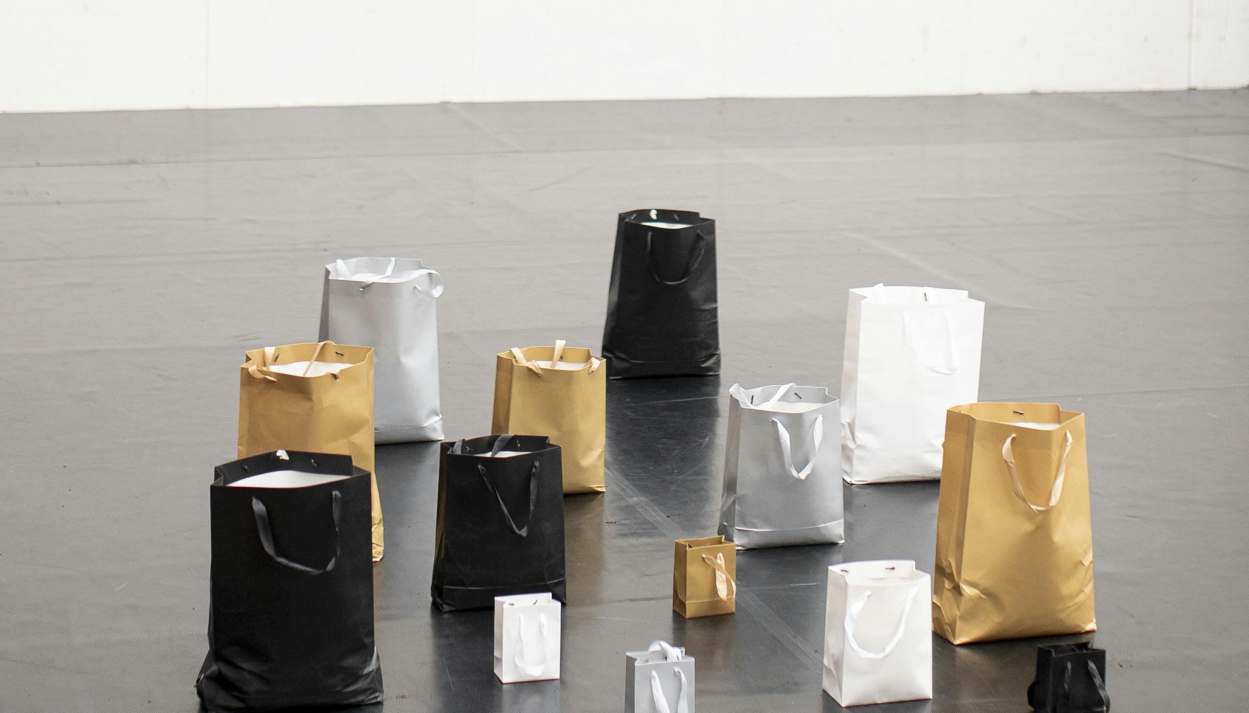 Serie di sacchetti di carta neri, bianchi, argentati e dorati di diverse misure