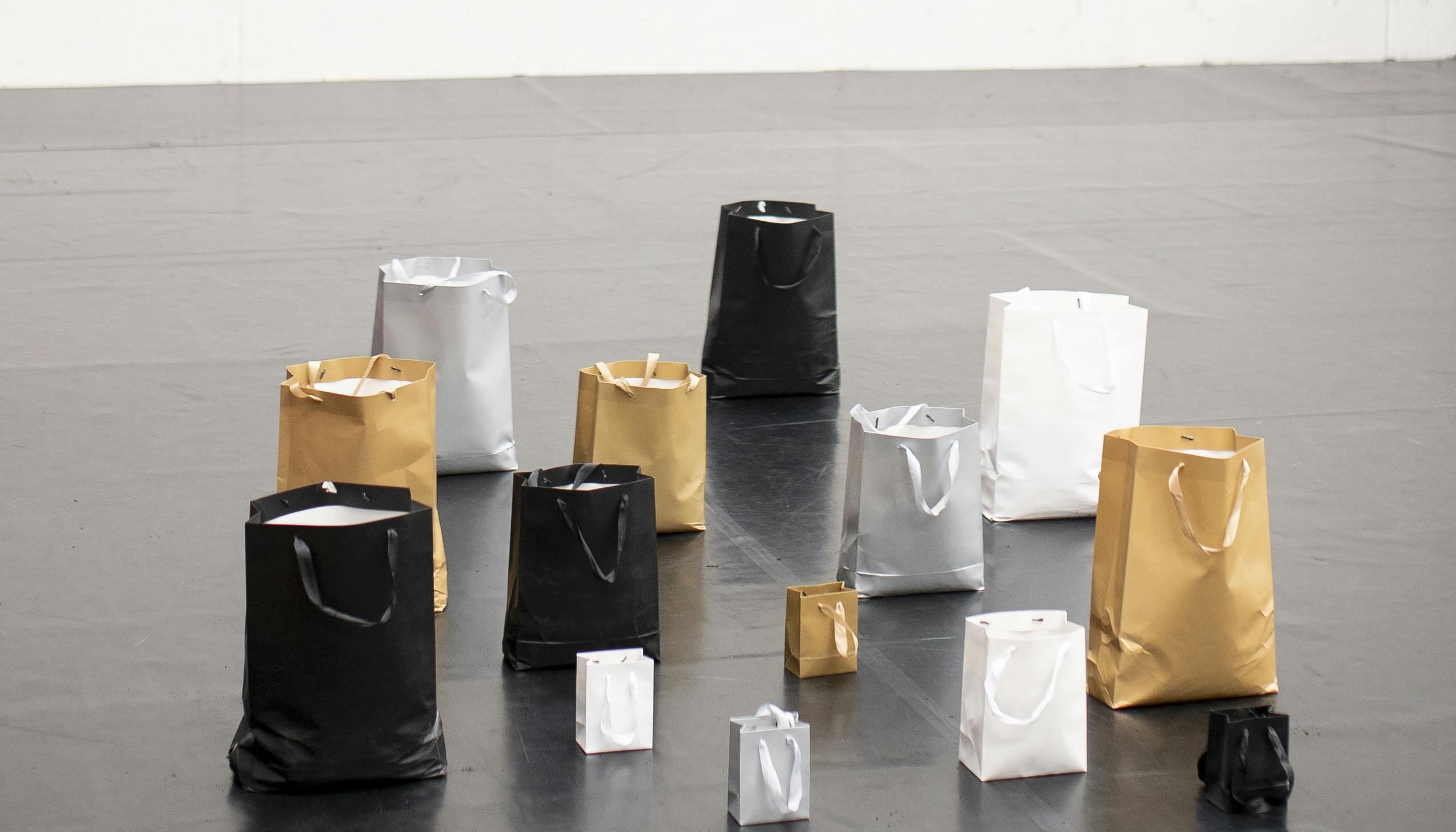Series of black, white, silver and gold paper bags in different sizes