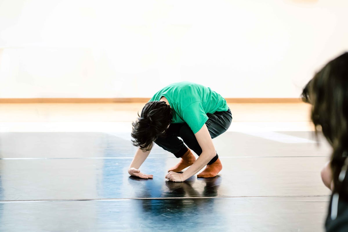 Teacher in the room during the workshop on her knees and hands to the floor.