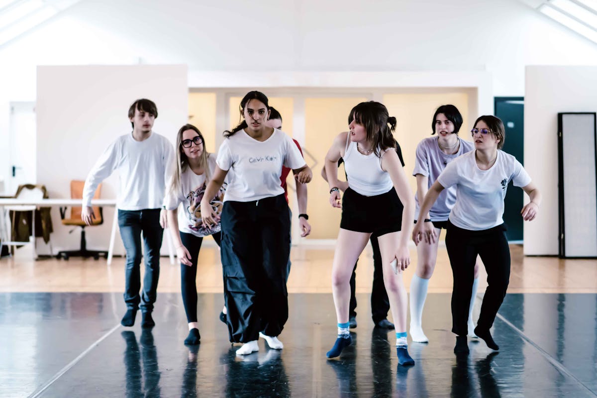 Boys and girls in the room during the Creature Selvagge workshop as they rehearse a group scene posing as animals.