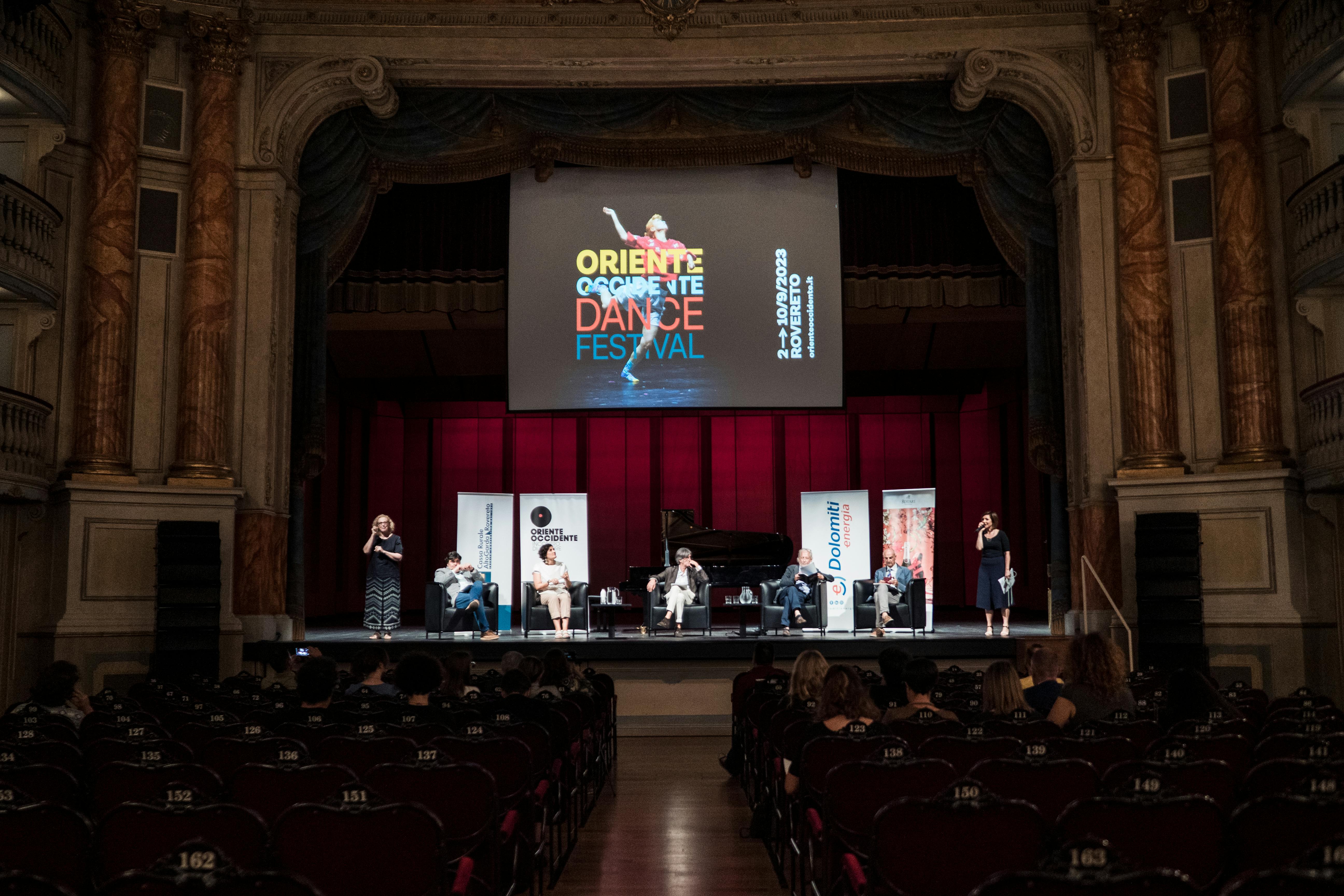 Foto dalla platea del Teatro Zandonai, sul palco sette persone presentano il festival e il programma.