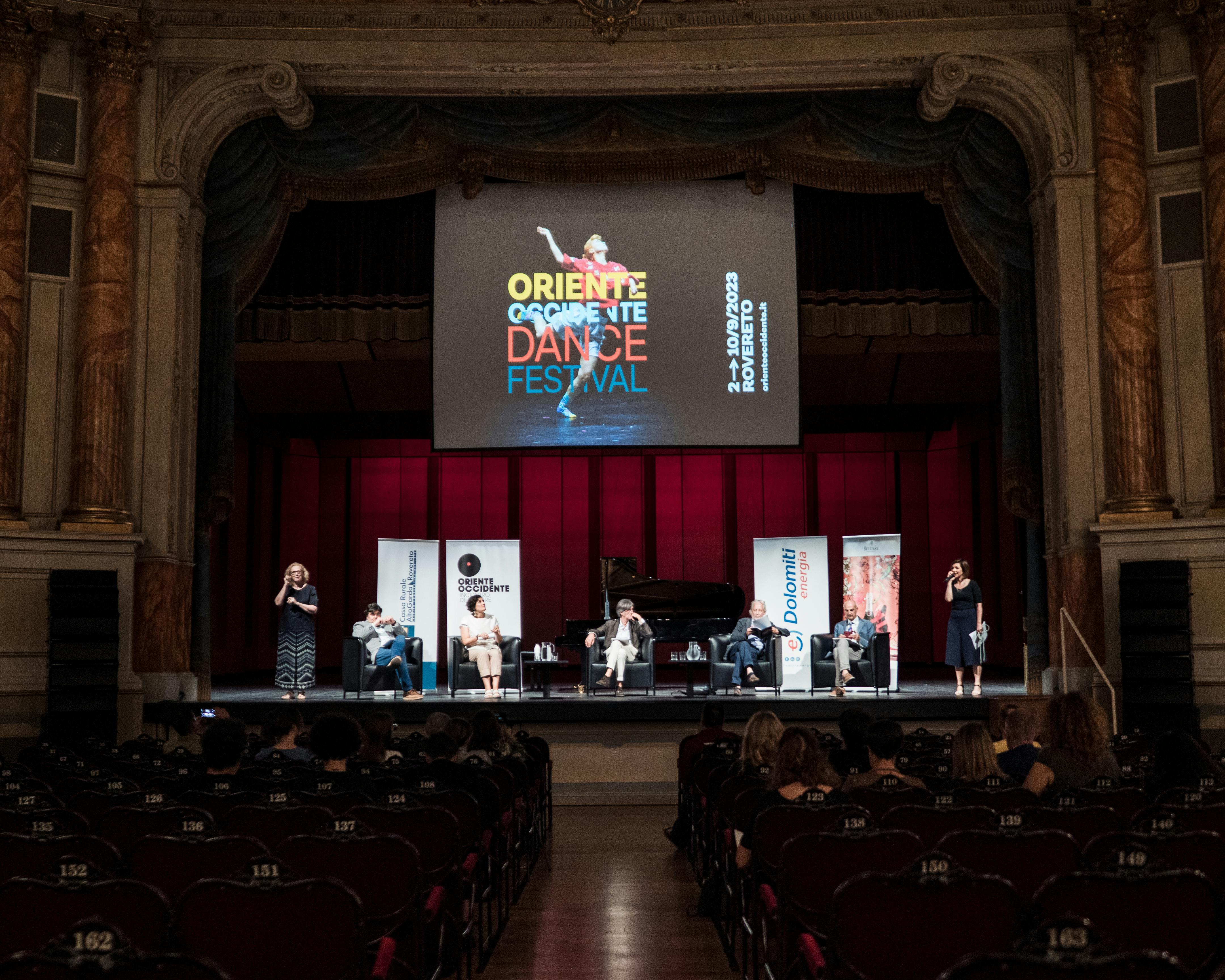 Foto dalla platea del Teatro Zandonai, sul palco sette persone presentano il festival e il programma.