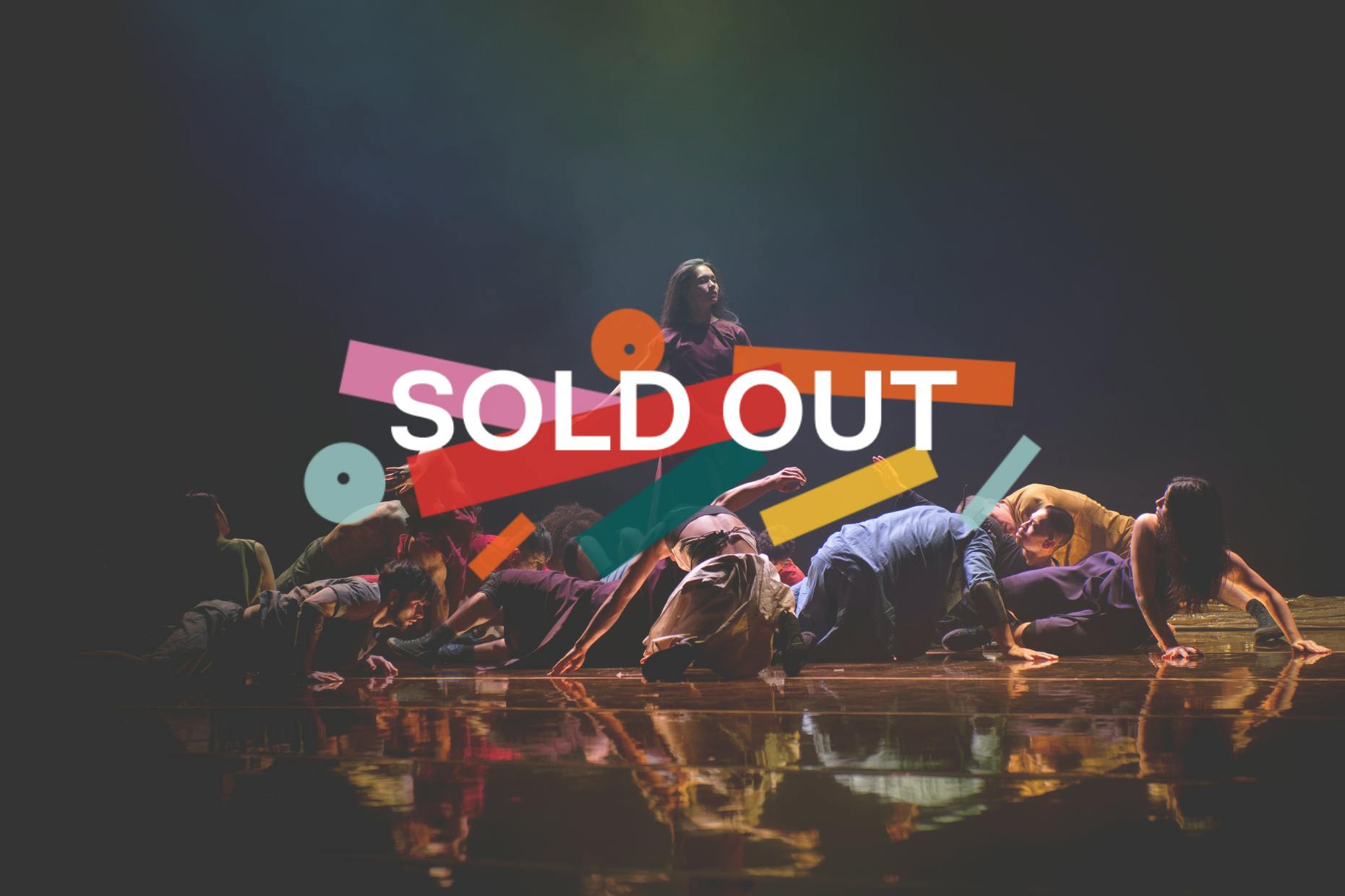 Sold out. A standing dancer in a purple dress is surrounded by kneeling or reclining dancers and dancers