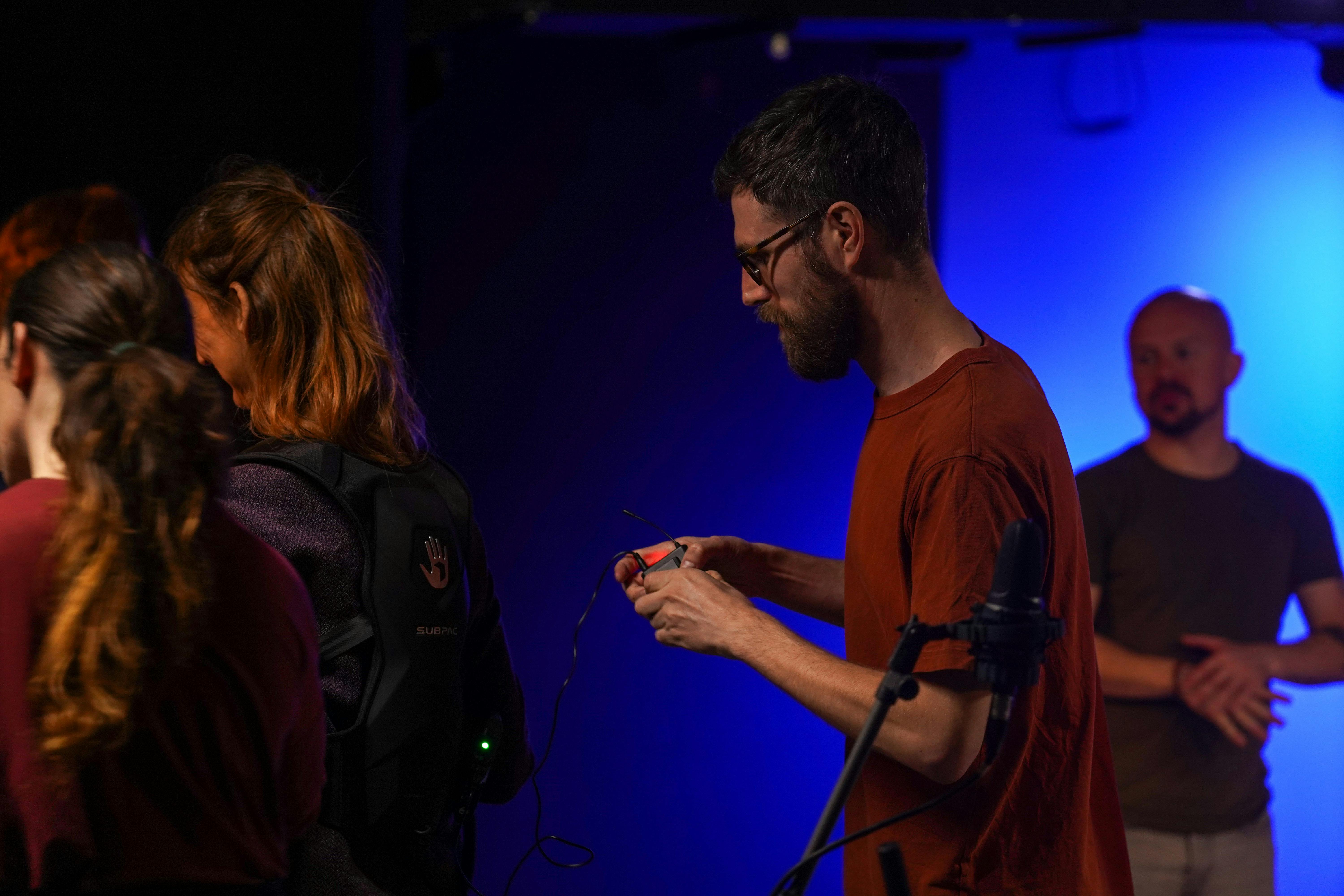 L'artista Tom White sta preparando all'uso il Subpac che indossa una donna