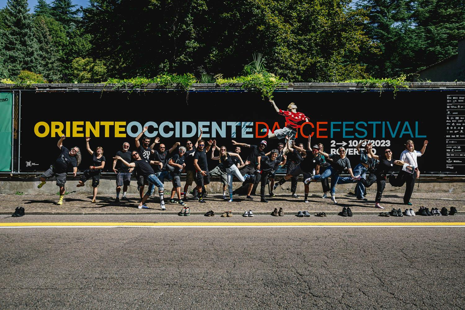 Lo staff di Oriente Occidente Dance Festival 2023 in una foto di gruppo mentre imitano la posa della ballerina presente sul manifesto.