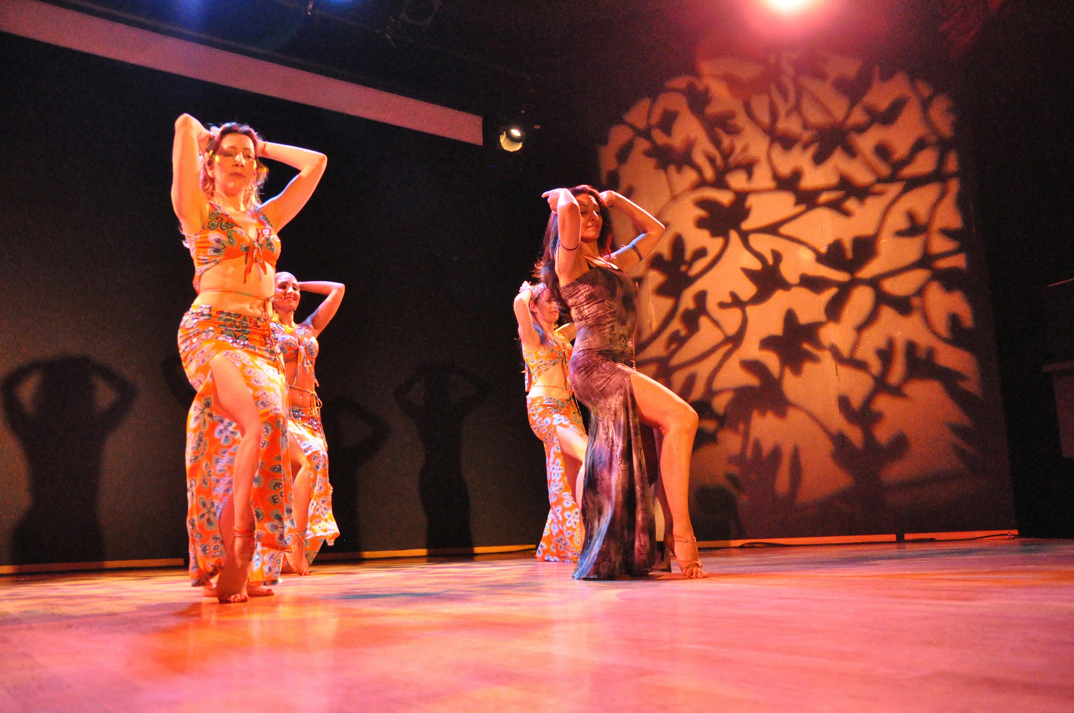 Quattro ballerine sul palco, in posa vestite con abiti indiani.