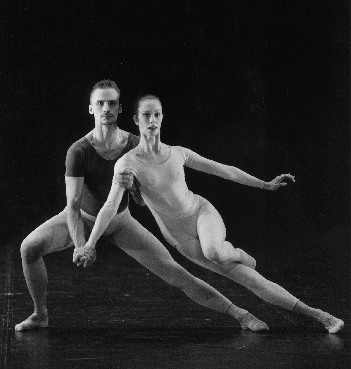 Due ballerini in scena. Il ballerino è piegano sulle proprie gambe, tiene la ballerina che è appoggiata a lui.