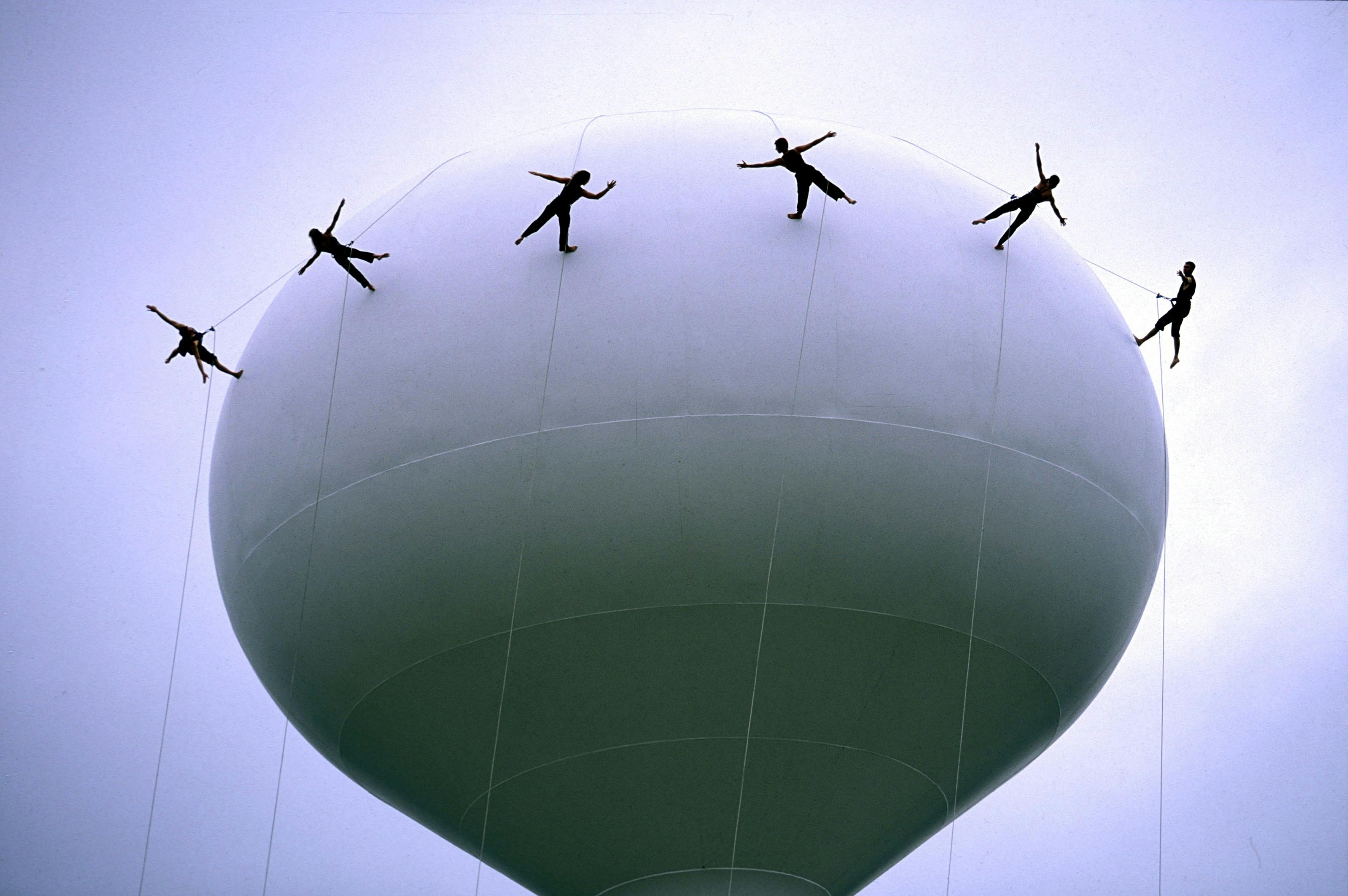 A hot air balloon with people walking on top of it.