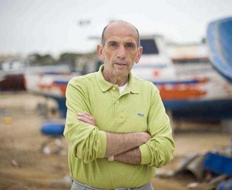 In the photo, Domenico Quirico, journalist for La Stampa, is looking seriously at the camera. He is standing with his arms crossed and wearing a green polo shirt.