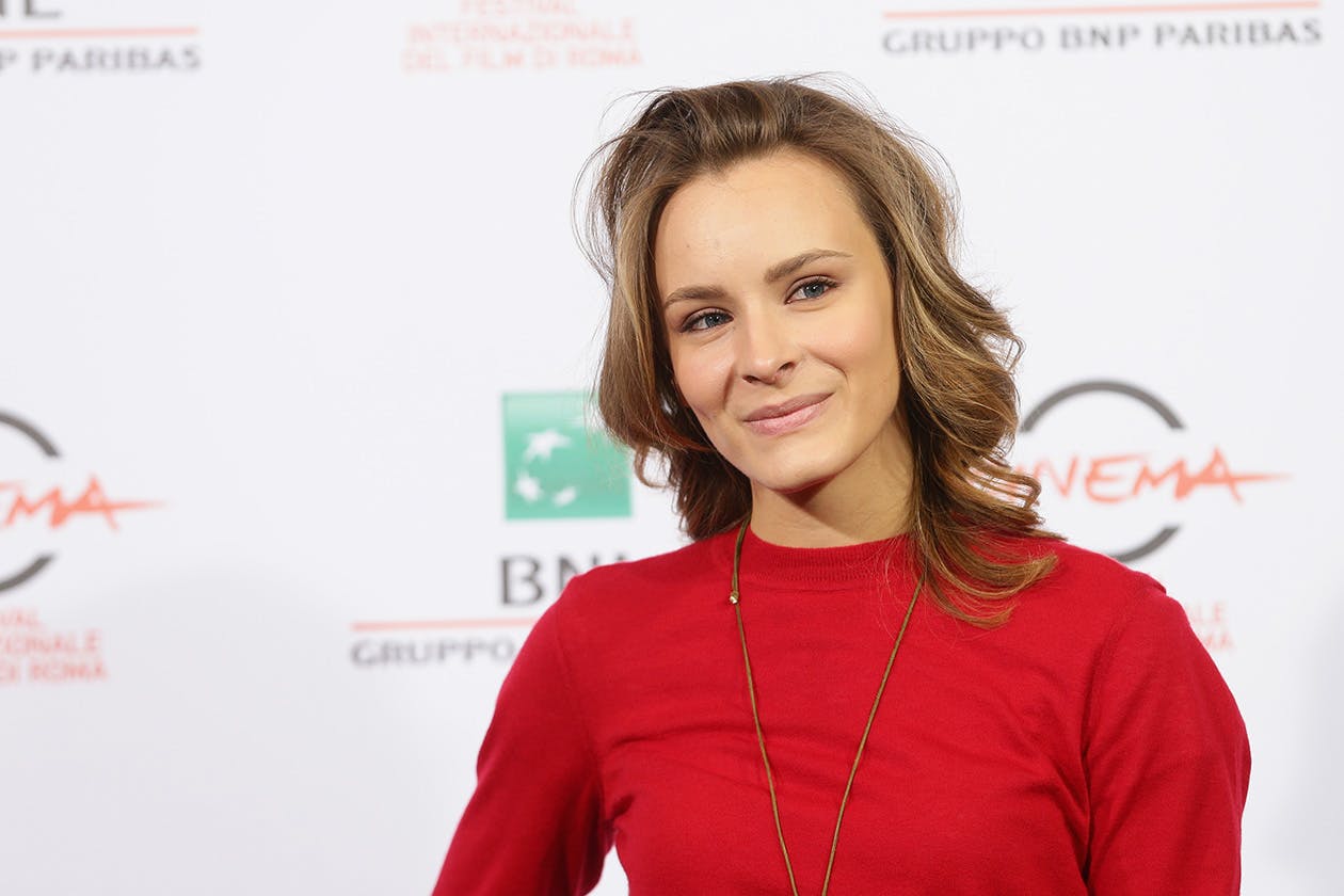 foto sul red carpet di Maria Roveran, attrice veneziana. Sorride ai fotografi. Indossa un pullover rosso.