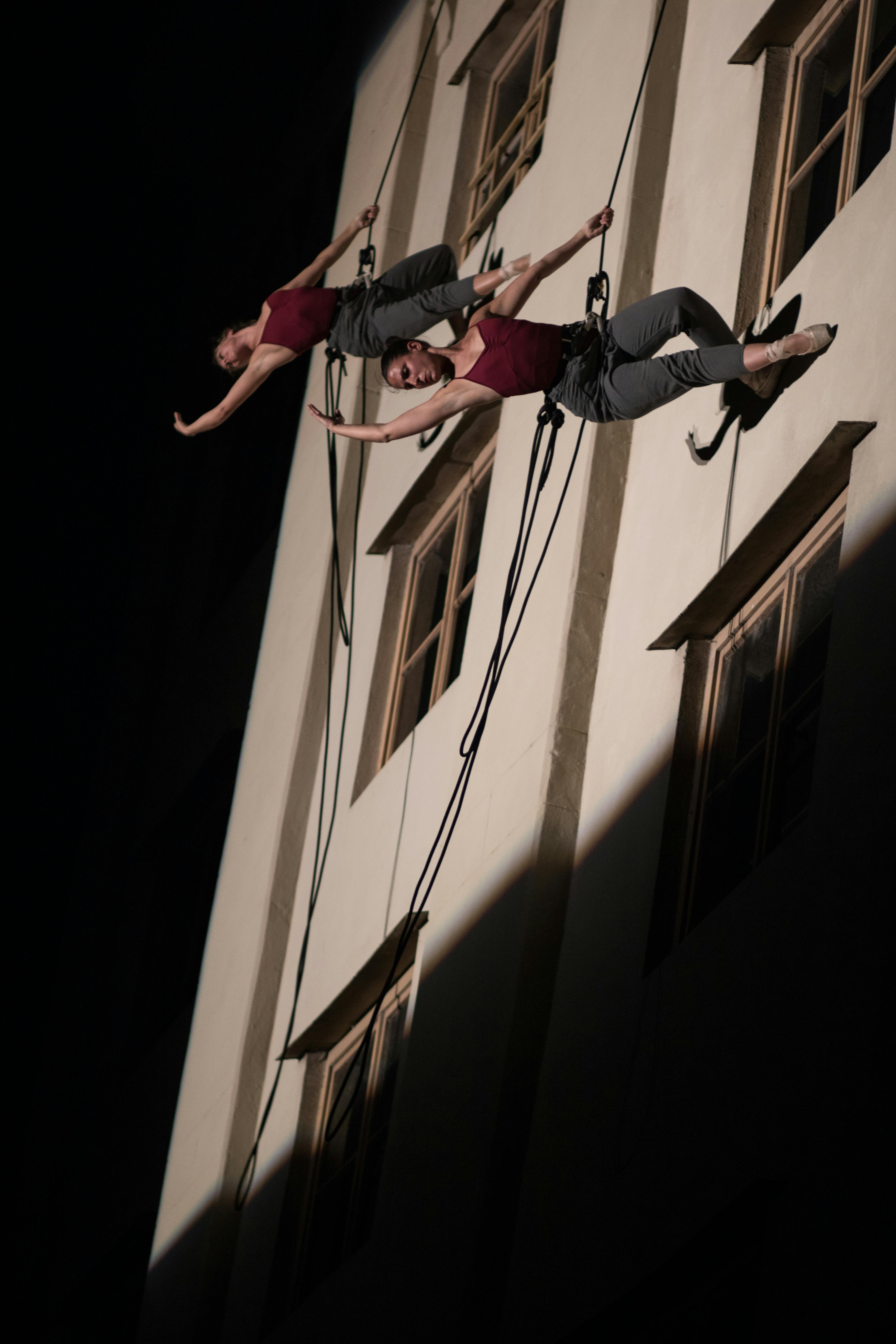 Due artiste orizzontali rispetto a un edificio. Sono attaccate con un imbrago