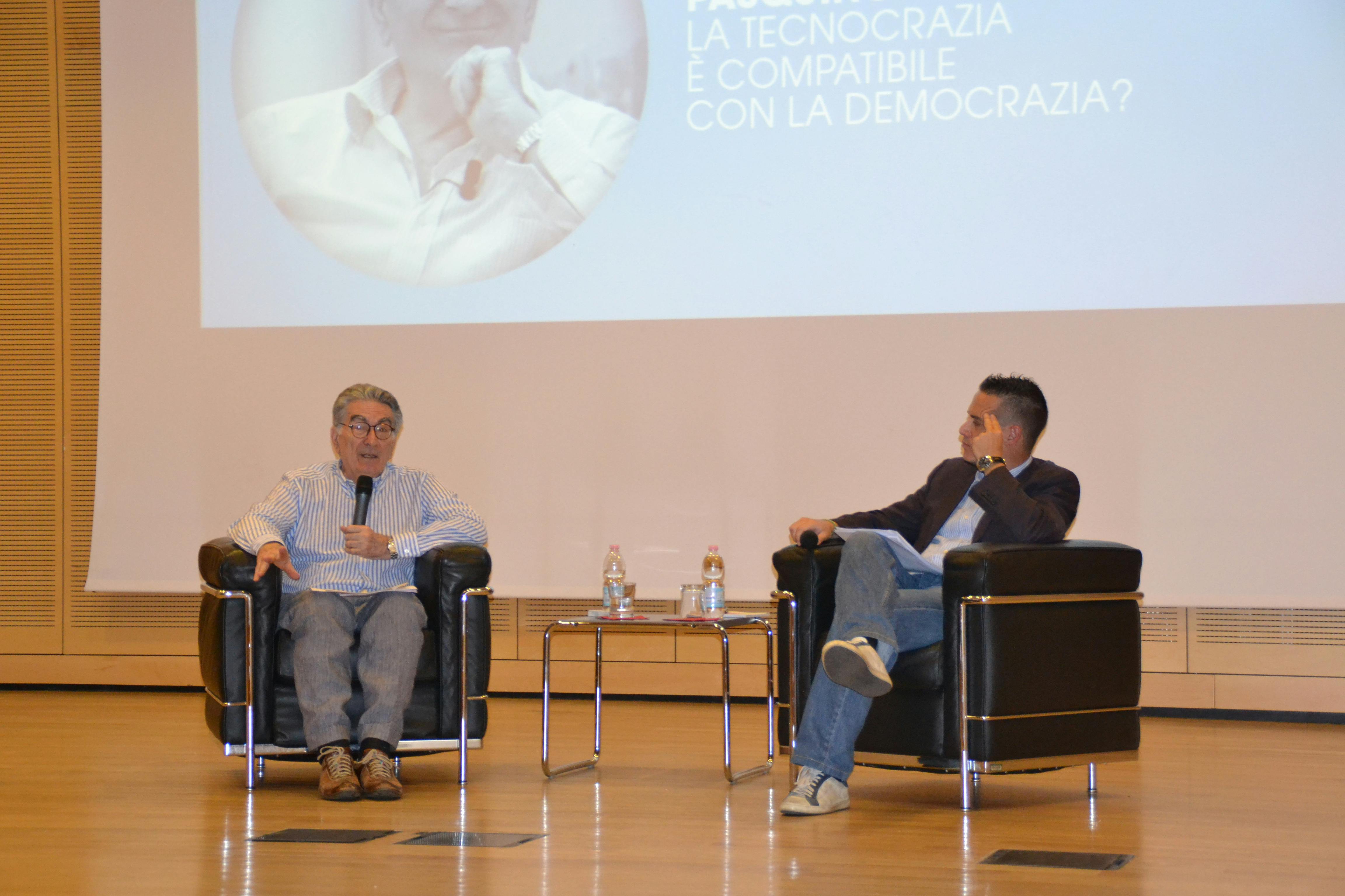 In the photo, Gianfranco Pasquino, university professor and writer, and Simone Casalini, deputy editor and columnist for Corriere del Trentino, are speaking on stage while sitting on chairs.