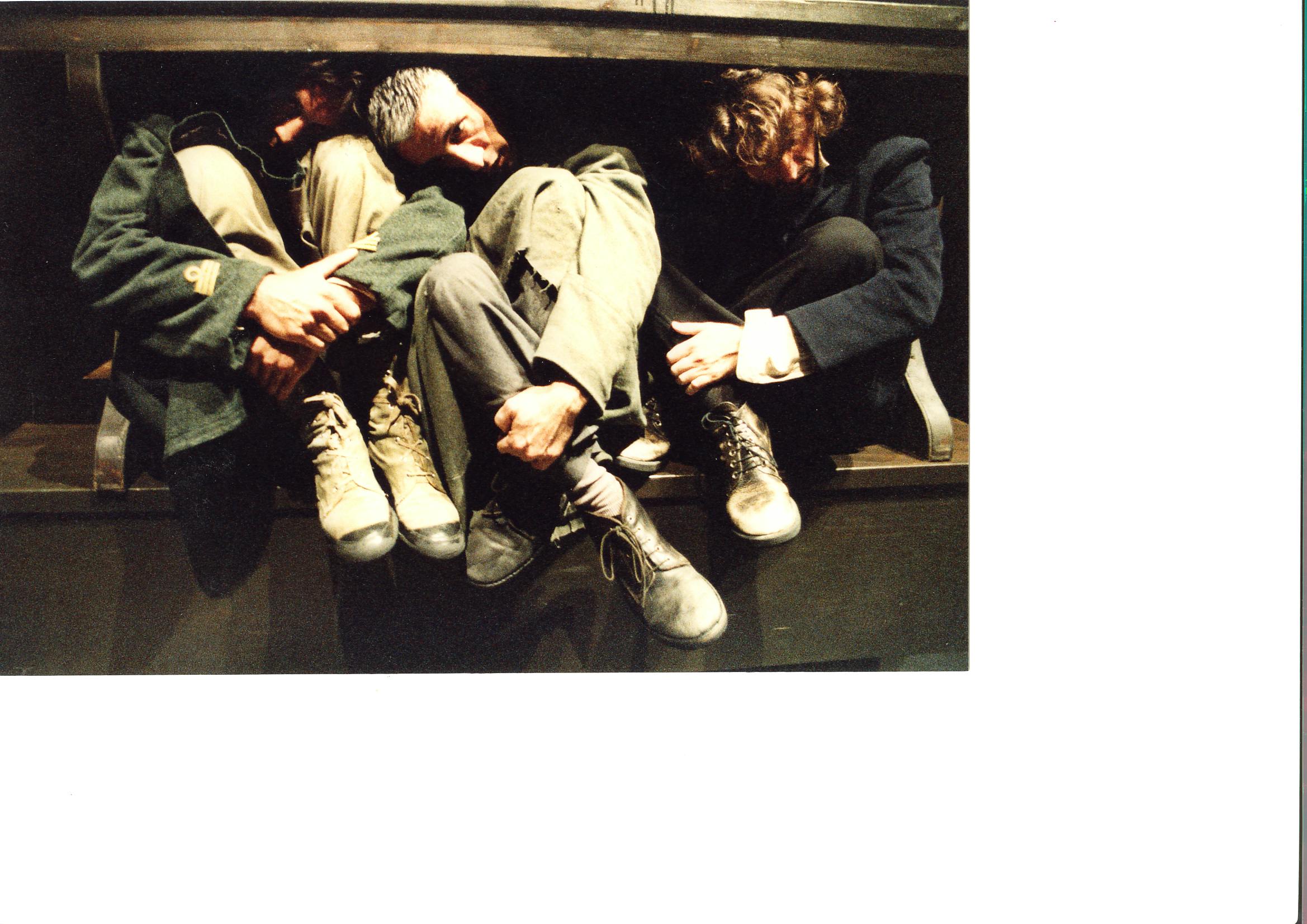Three artists crouched under a table.