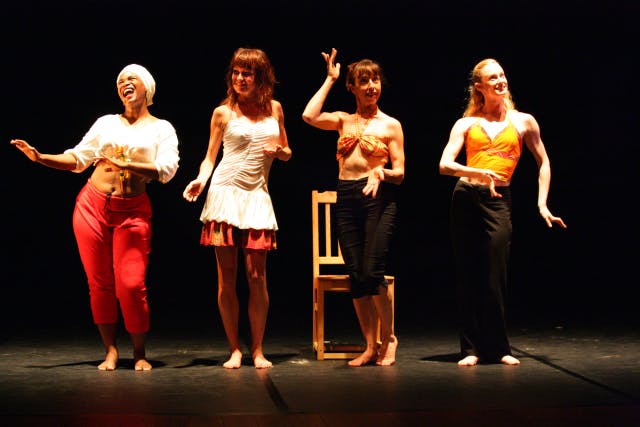 quattro artiste in linea sul palco vestite colorate con pose diverse