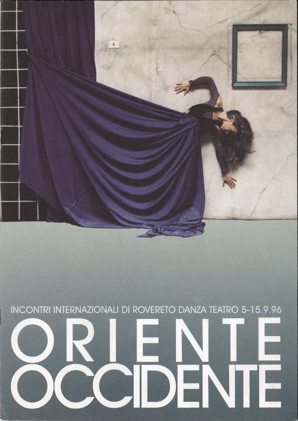 Lavoro grafico del Festival: l'immagine mostra una figura femminile che sembra emergere da una tenda blu scura su uno sfondo di parete bianca. Il titolo Oriente Occidente in bianco è in basso sull'immagine.