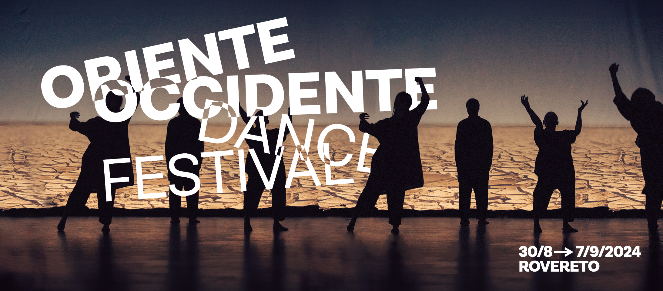 Sullo sfondo un deserto arido e un cielo blu al crepuscolo, in primo piano la silhouette di un gruppo di persone danza. In bianco il lettering Oriente Occidente Dance Festival