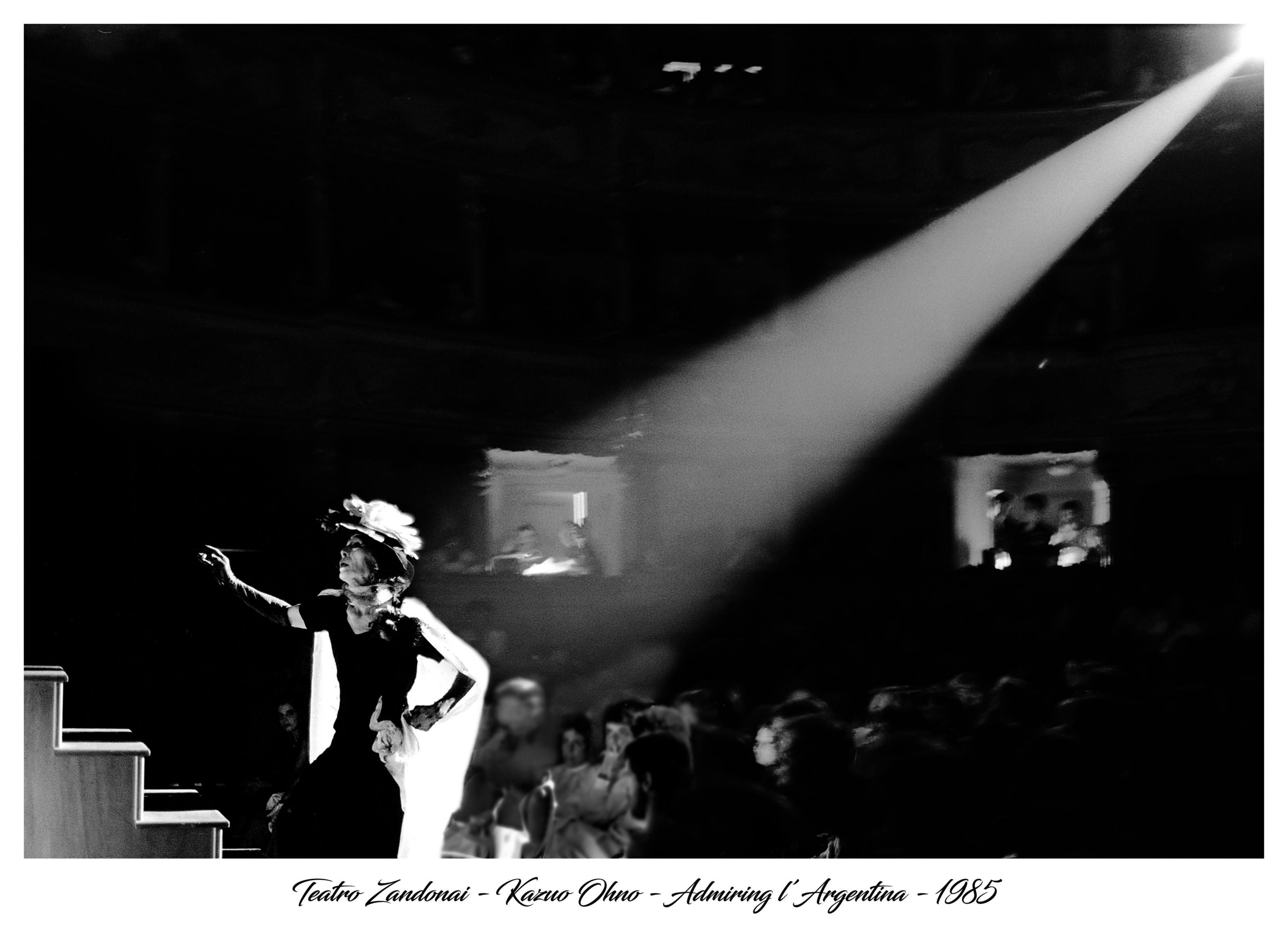 An artist wearing typical Argentinean attire, illuminated by a spotlight.