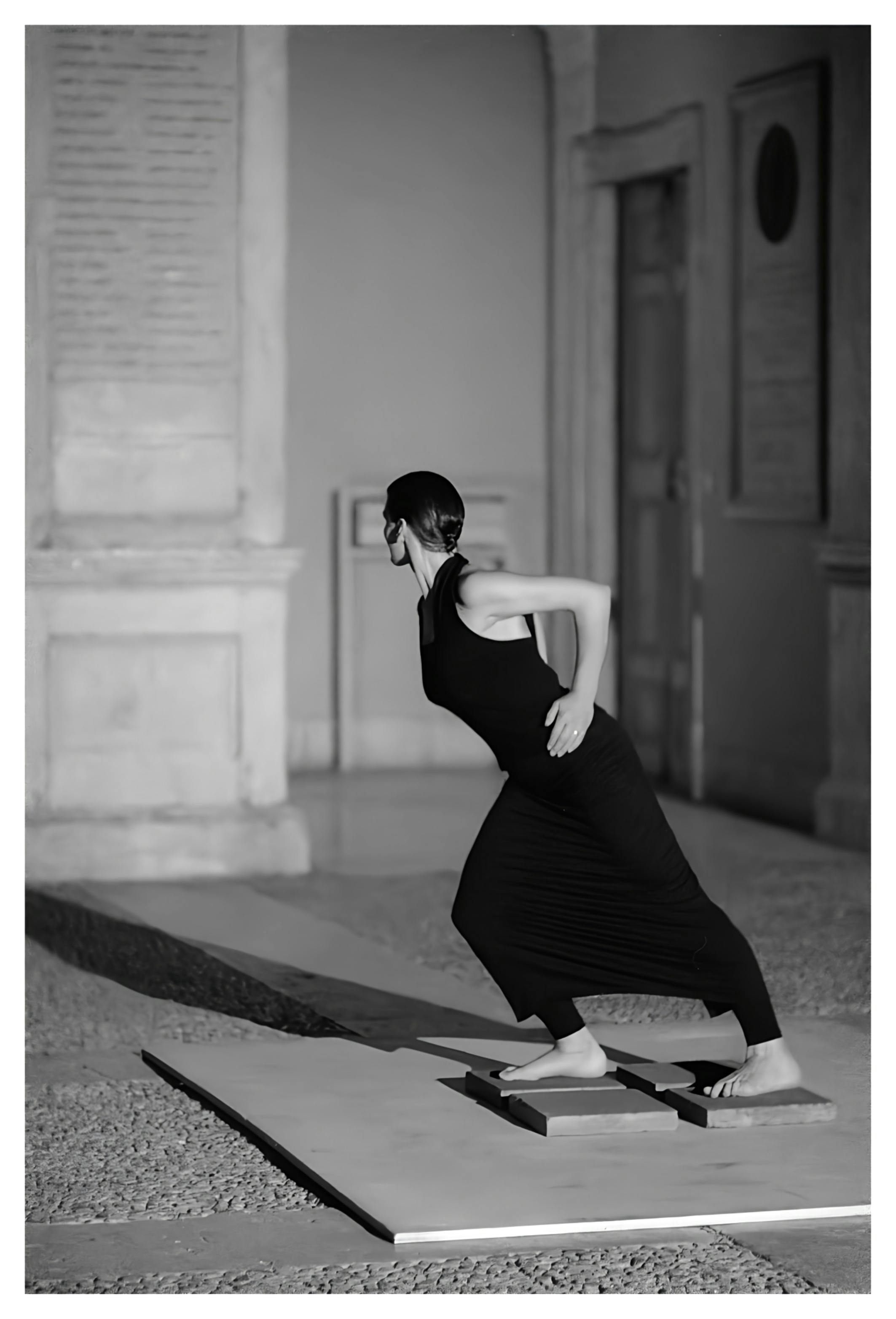 An artist with their body leaning forward, head looking back, and arms bent.
