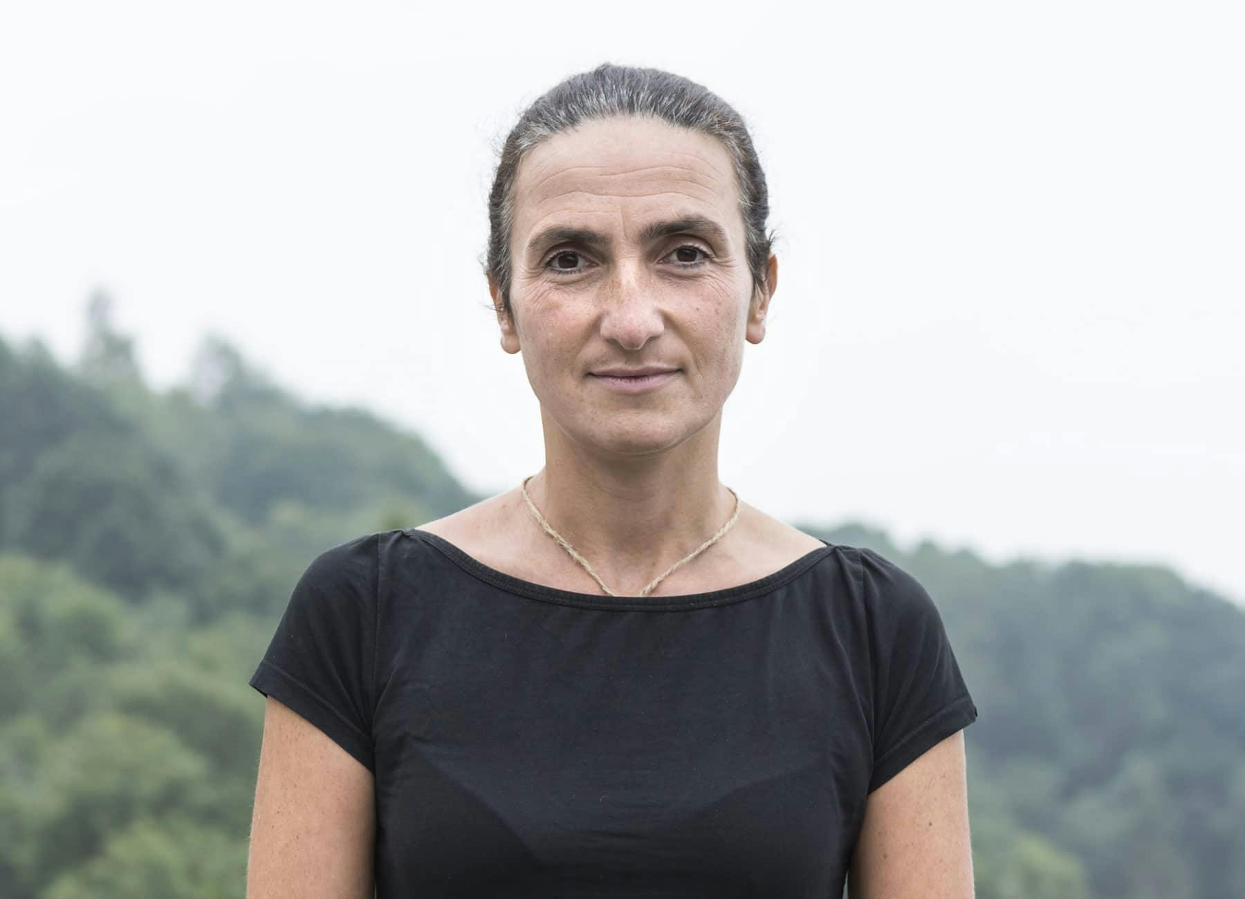 Primo piano della relatrice Emanuela Zilio. Guarda davanti a sè verso la fotocamera. Indossa una maglietta nera. Ha i capelli raccolti in uno chignon stretto.