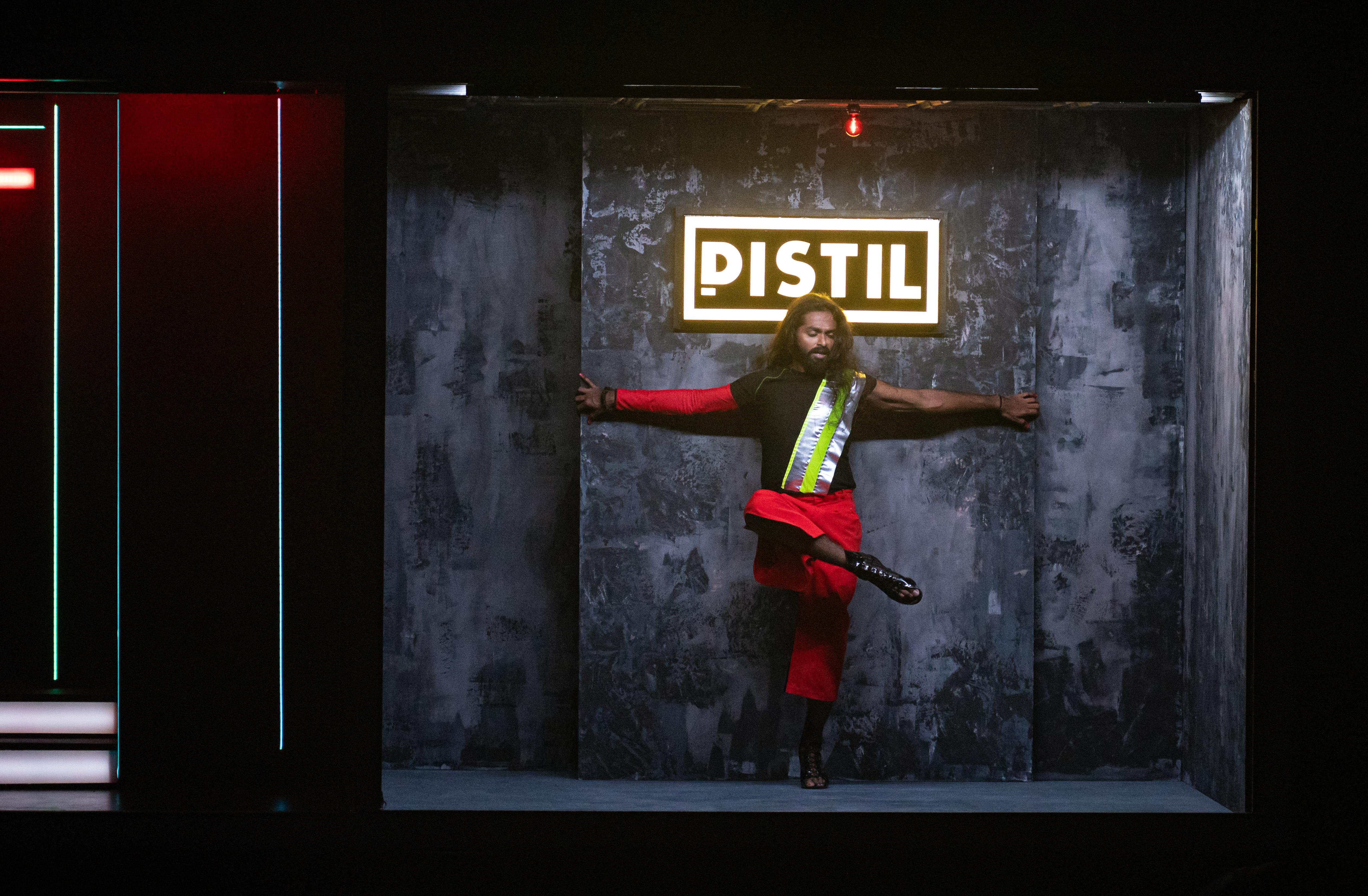 Un danzatore in posa davanti alla scritta al neon Pistil