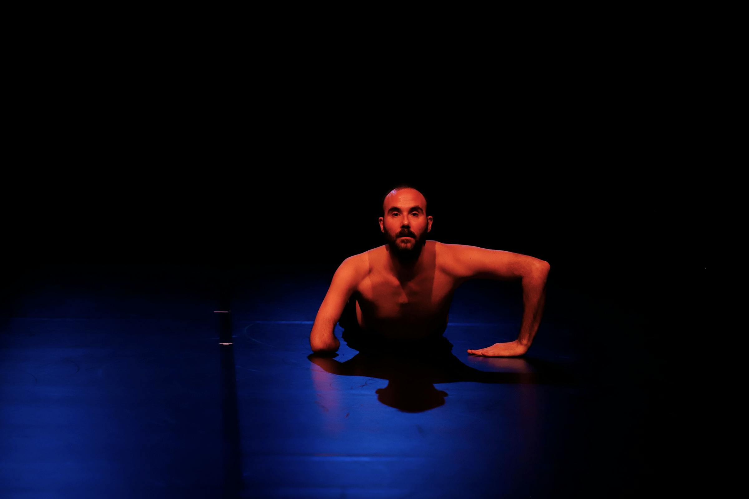 Choreographer Aristide Rontini in a static pose lying on the ground