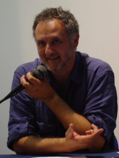 Ritratto del professore Marco Aime mentre parla al microfono sorridendo