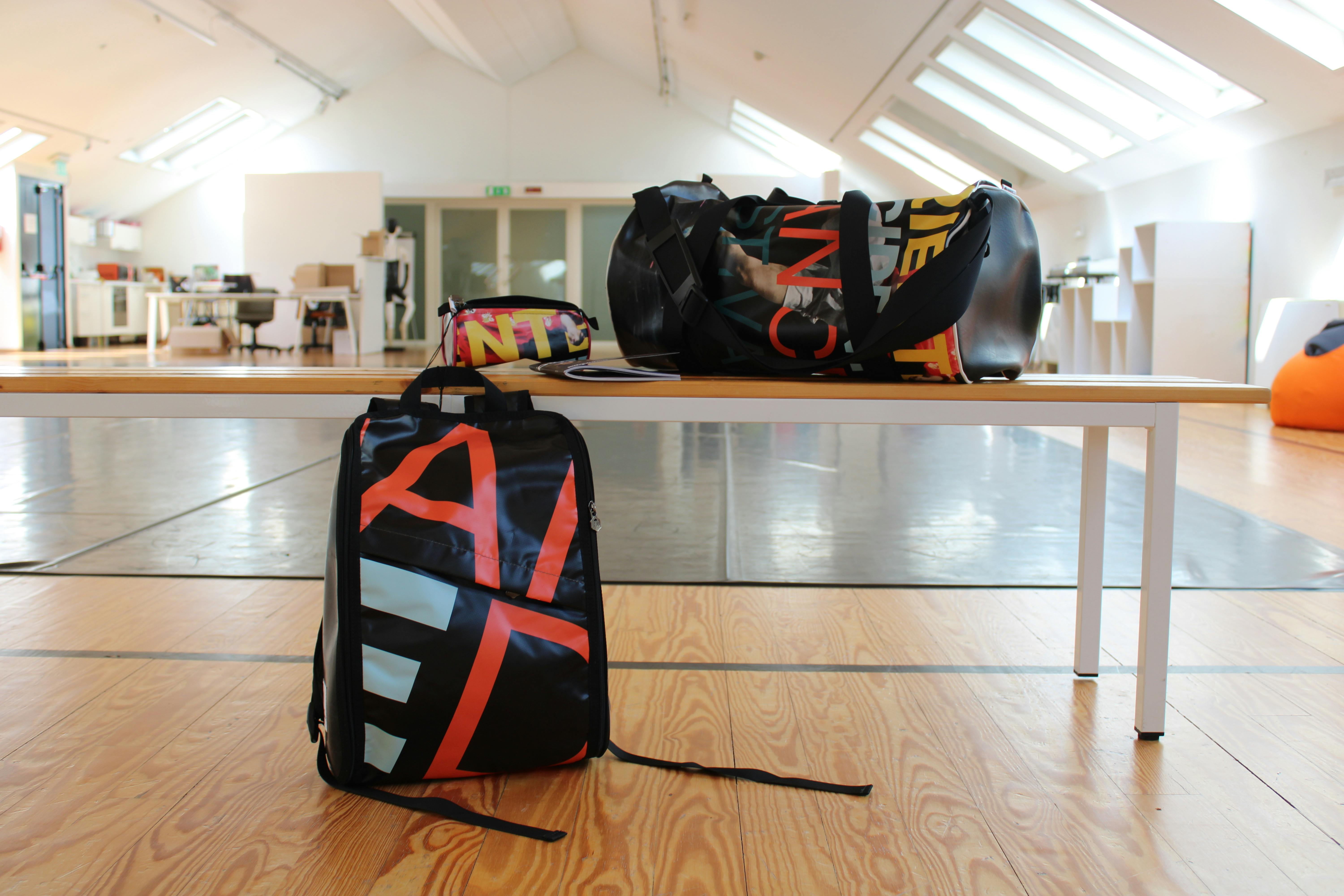 Backpack, pencil case and large bag resting on a bench in our dance studio