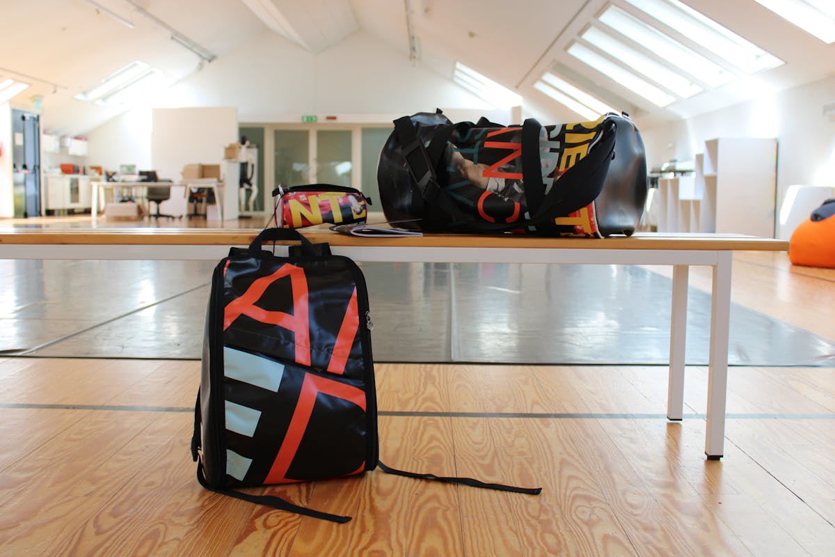 Backpack, pencil case and large bag resting on a bench in our dance studio