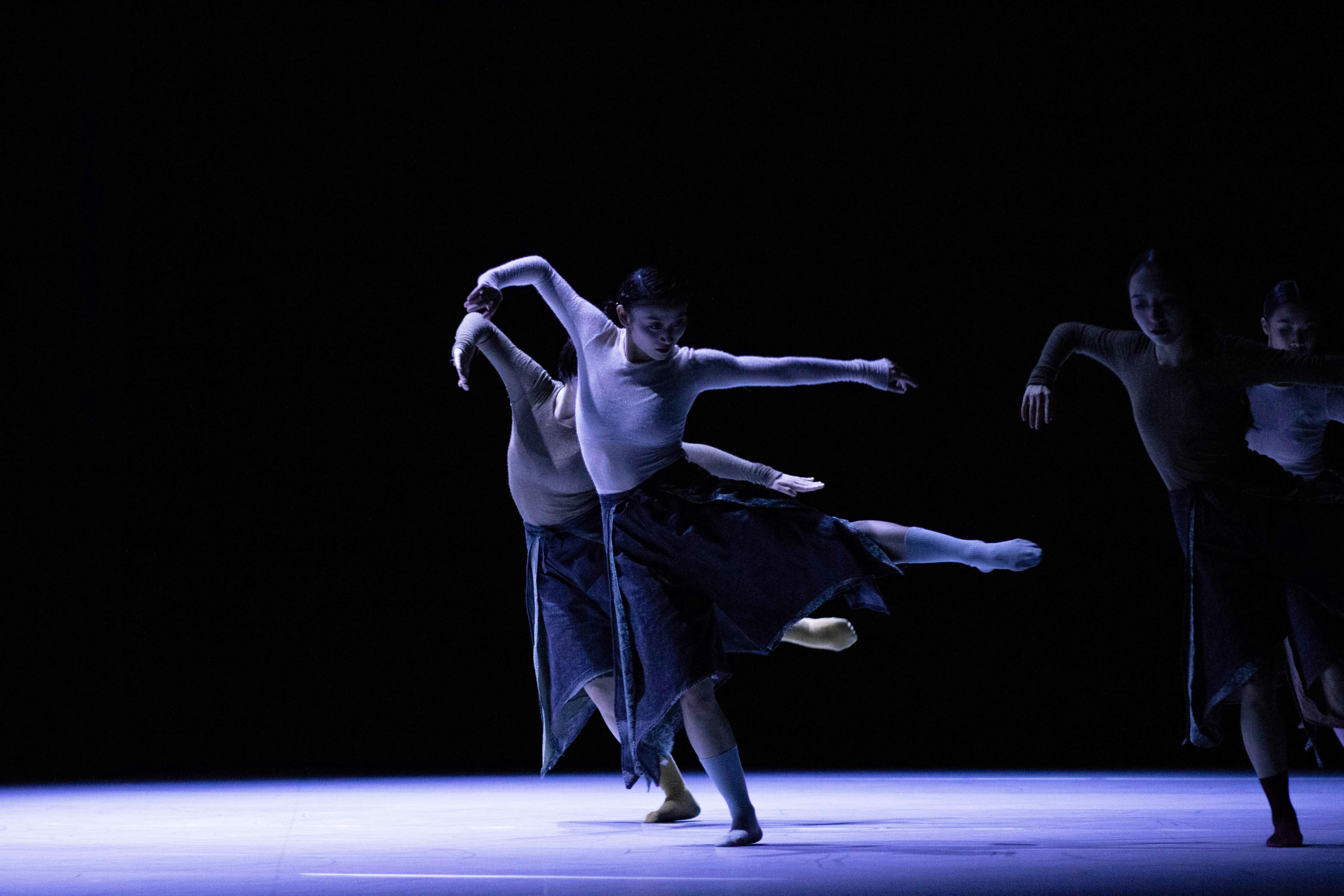 Quattro ballerine in scena in una posa di danza con le braccia tese ed una gamba alzata